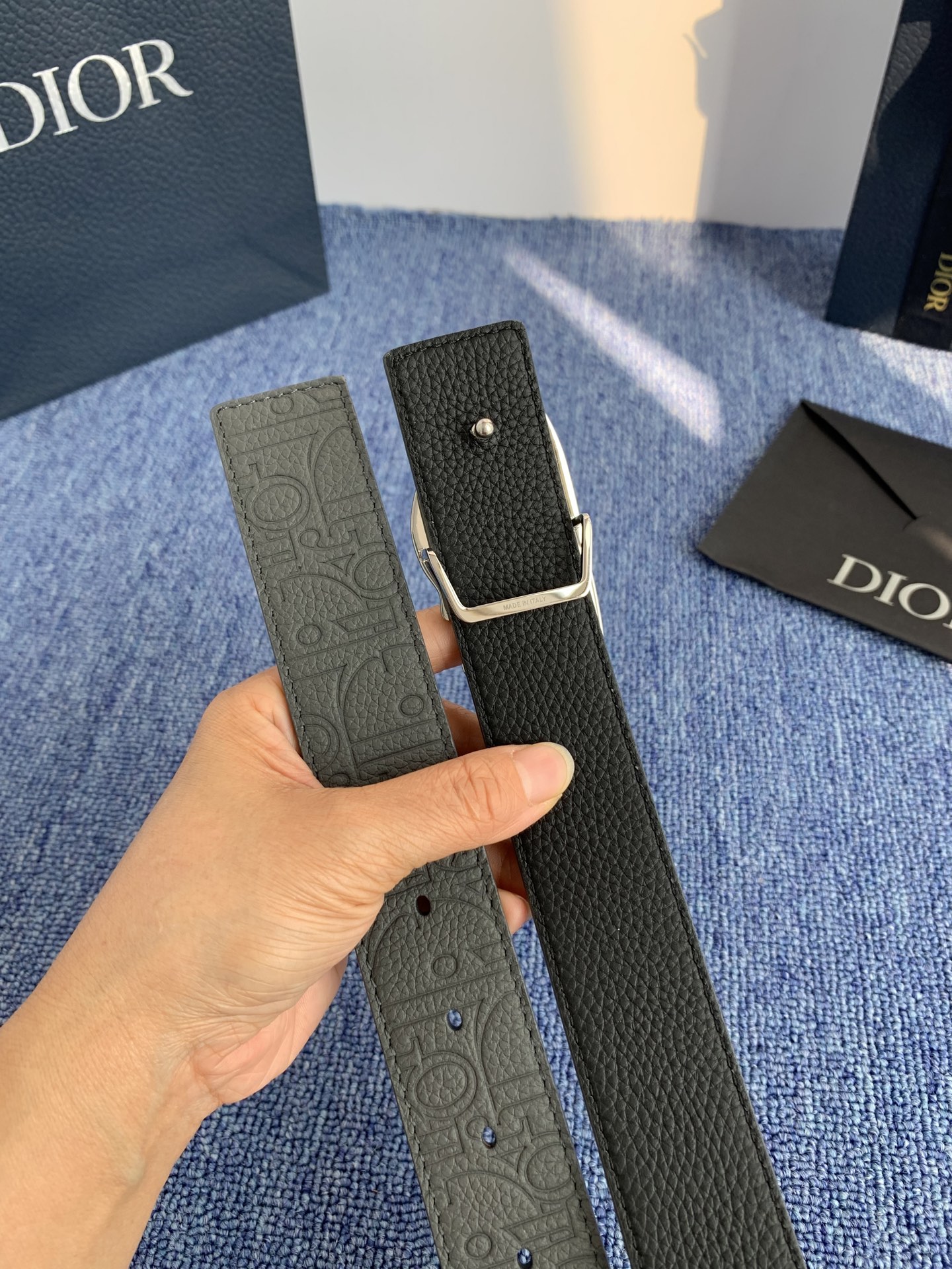 采用黑色粒面牛皮革精心制作，饰以镌刻有 Dior 的针扣和黑色金属覆层铜合金 CD Icon 标志腰带环