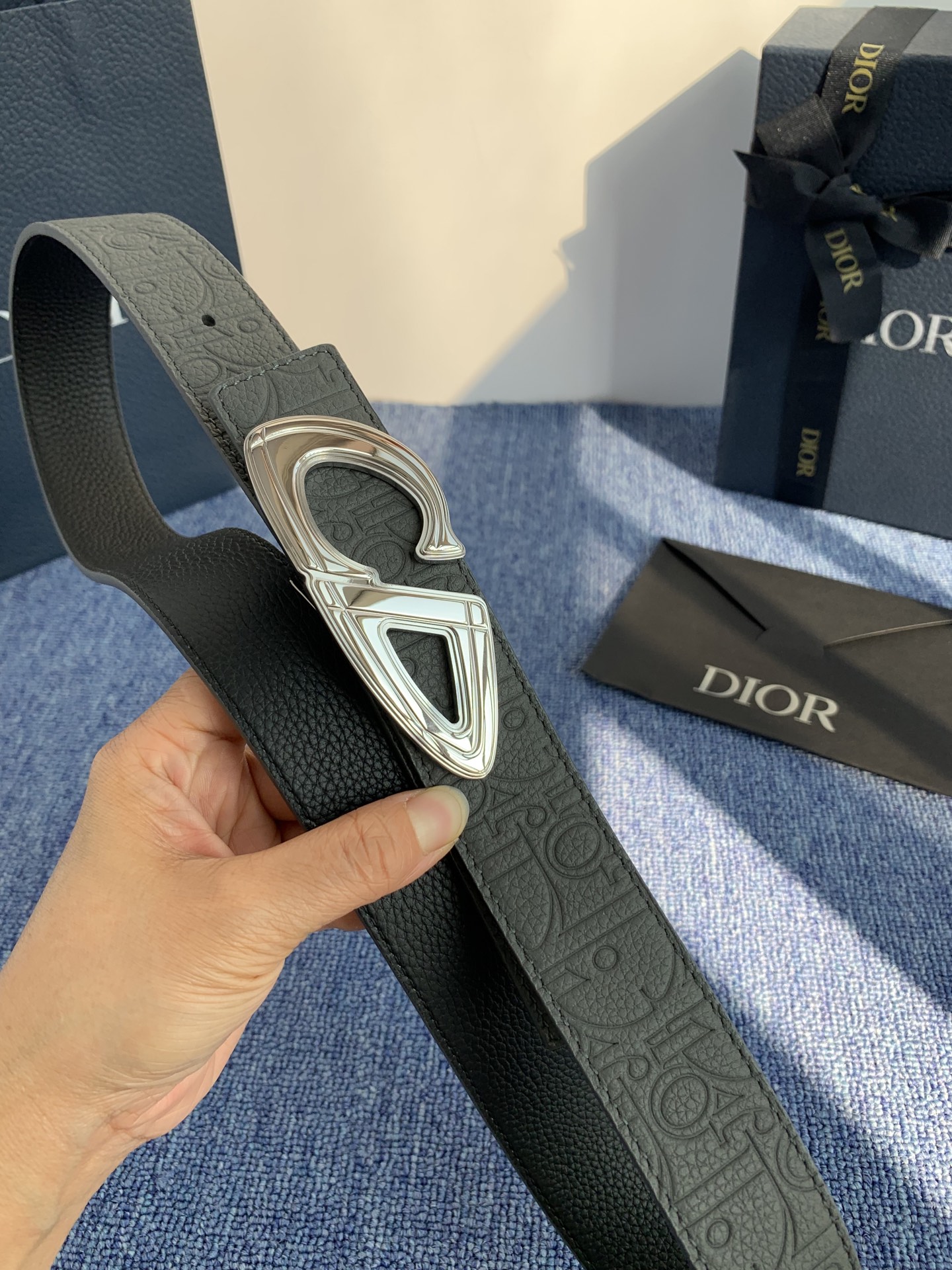 采用黑色粒面牛皮革精心制作，饰以镌刻有 Dior 的针扣和黑色金属覆层铜合金 CD Icon 标志腰带环