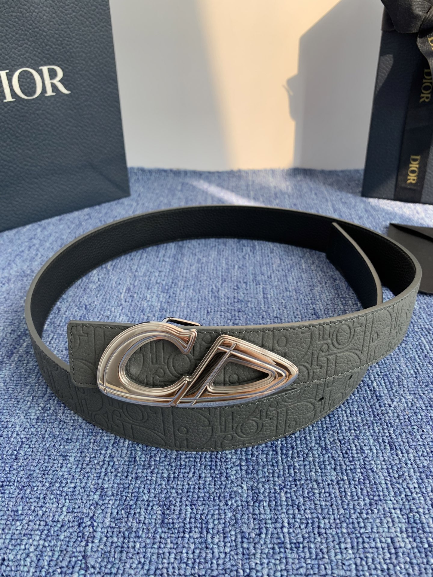 采用黑色粒面牛皮革精心制作，饰以镌刻有 Dior 的针扣和黑色金属覆层铜合金 CD Icon 标志腰带环