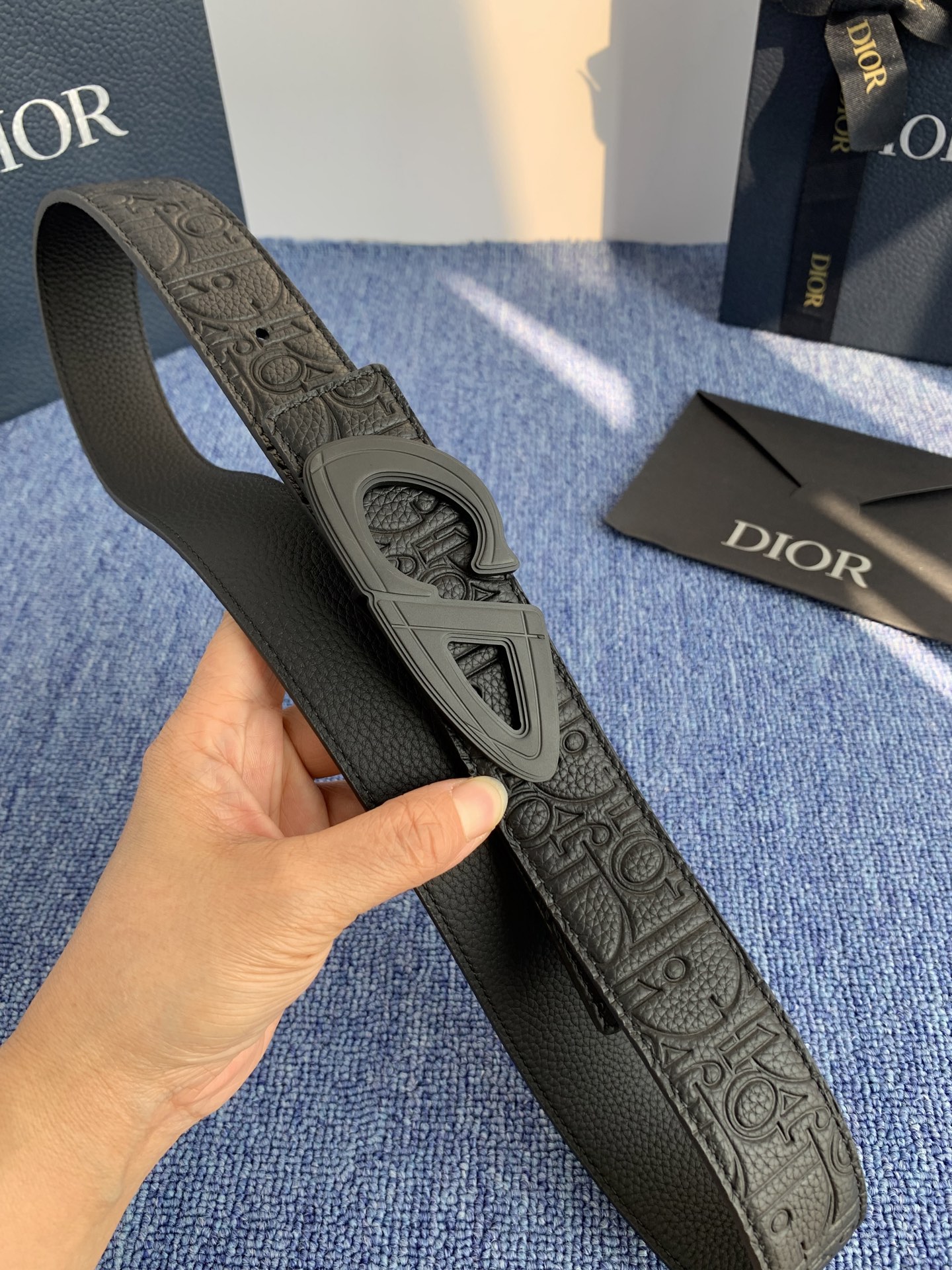 采用黑色粒面牛皮革精心制作，饰以镌刻有 Dior 的针扣和黑色金属覆层铜合金 CD Icon 标志腰带环