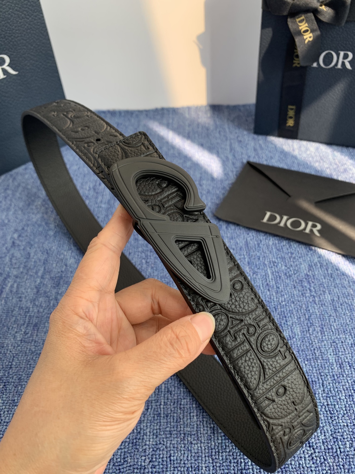采用黑色粒面牛皮革精心制作，饰以镌刻有 Dior 的针扣和黑色金属覆层铜合金 CD Icon 标志腰带环