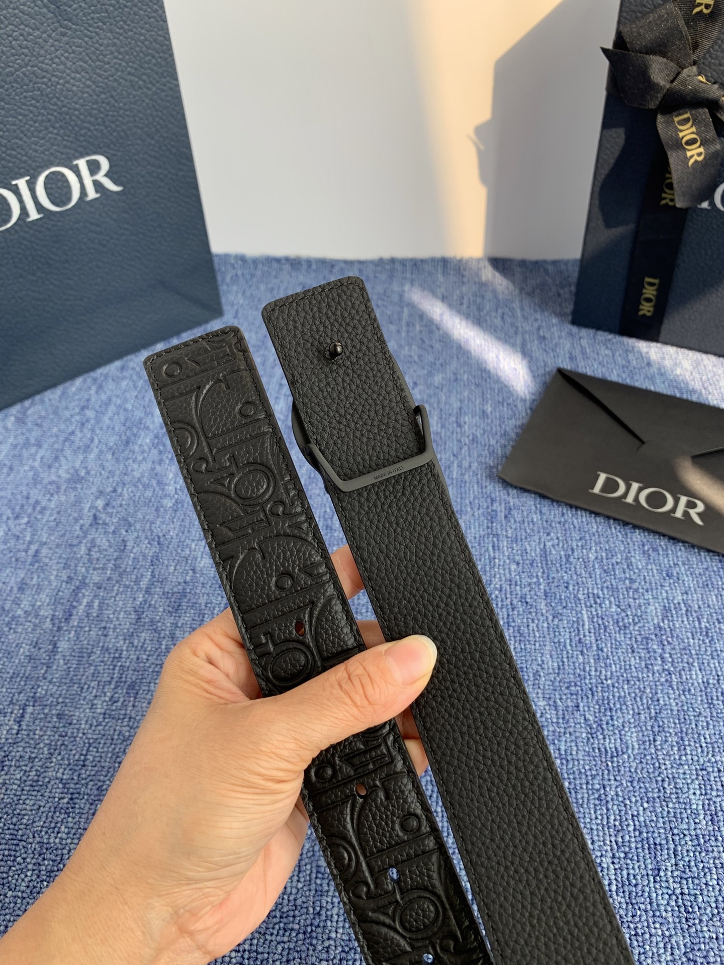 采用黑色粒面牛皮革精心制作，饰以镌刻有 Dior 的针扣和黑色金属覆层铜合金 CD Icon 标志腰带环