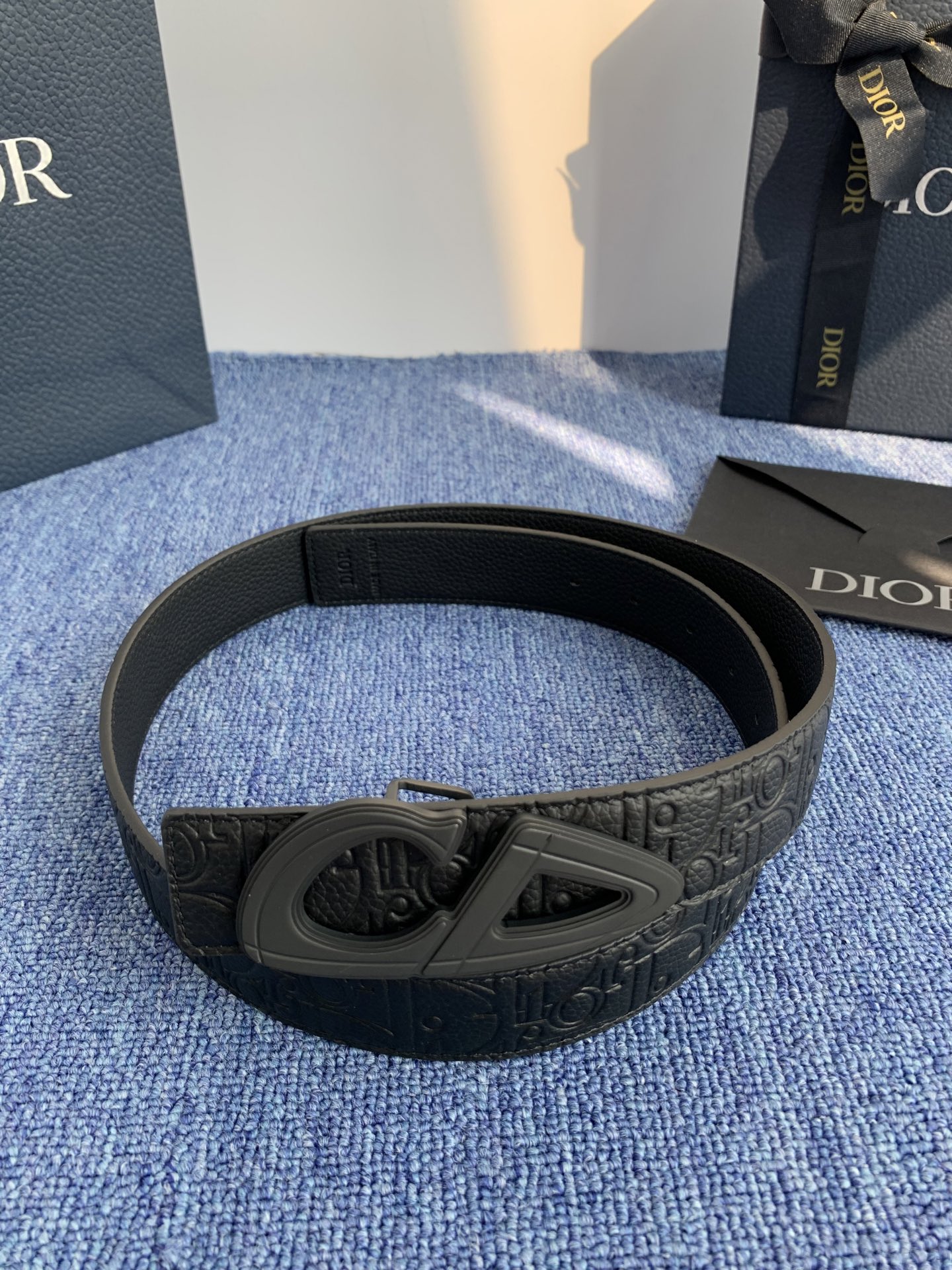 采用黑色粒面牛皮革精心制作，饰以镌刻有 Dior 的针扣和黑色金属覆层铜合金 CD Icon 标志腰带环