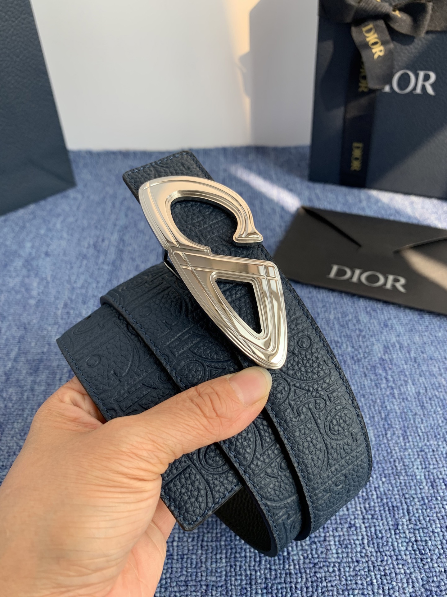 采用黑色粒面牛皮革精心制作，饰以镌刻有 Dior 的针扣和黑色金属覆层铜合金 CD Icon 标志腰带环