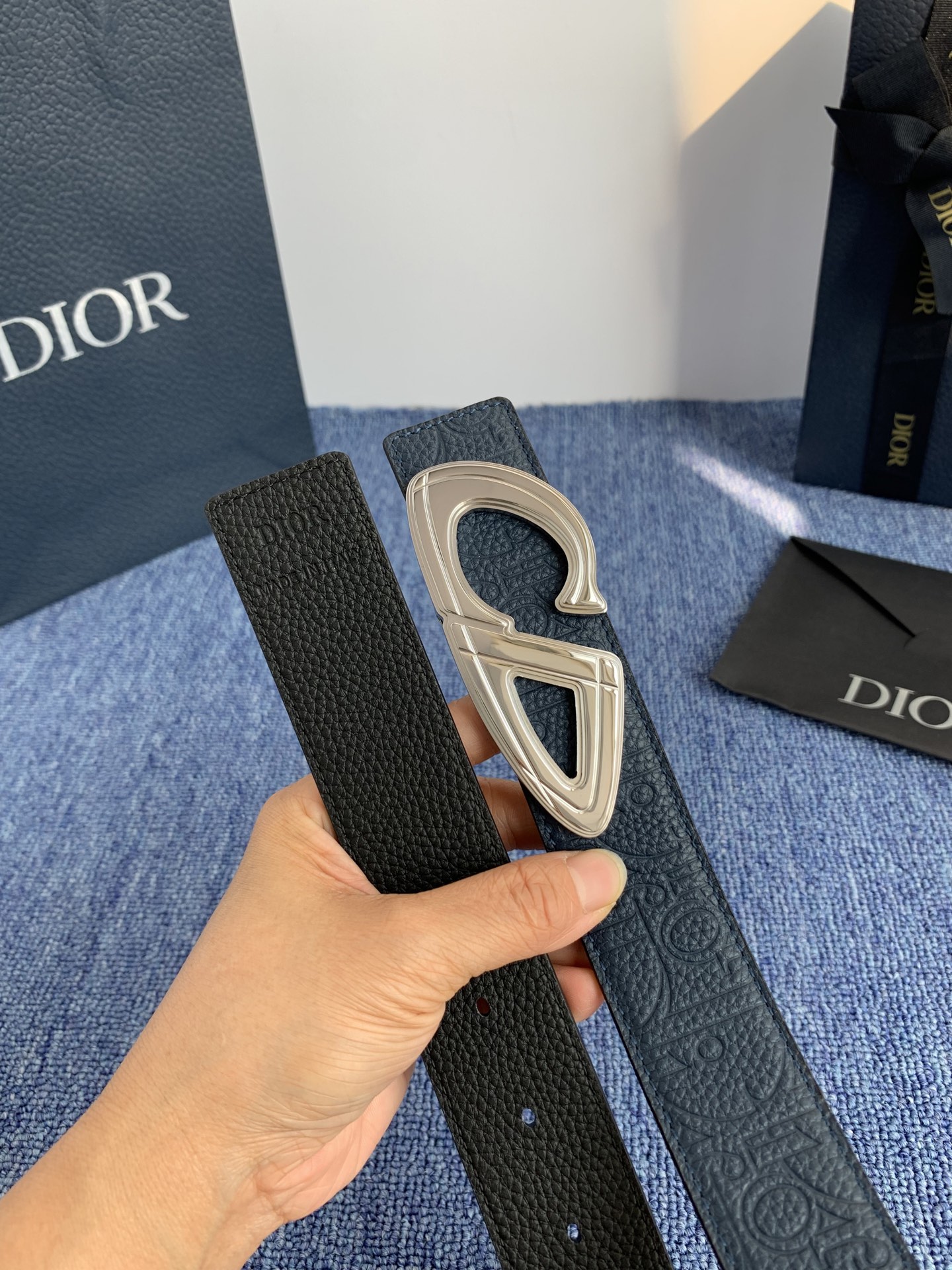 采用黑色粒面牛皮革精心制作，饰以镌刻有 Dior 的针扣和黑色金属覆层铜合金 CD Icon 标志腰带环
