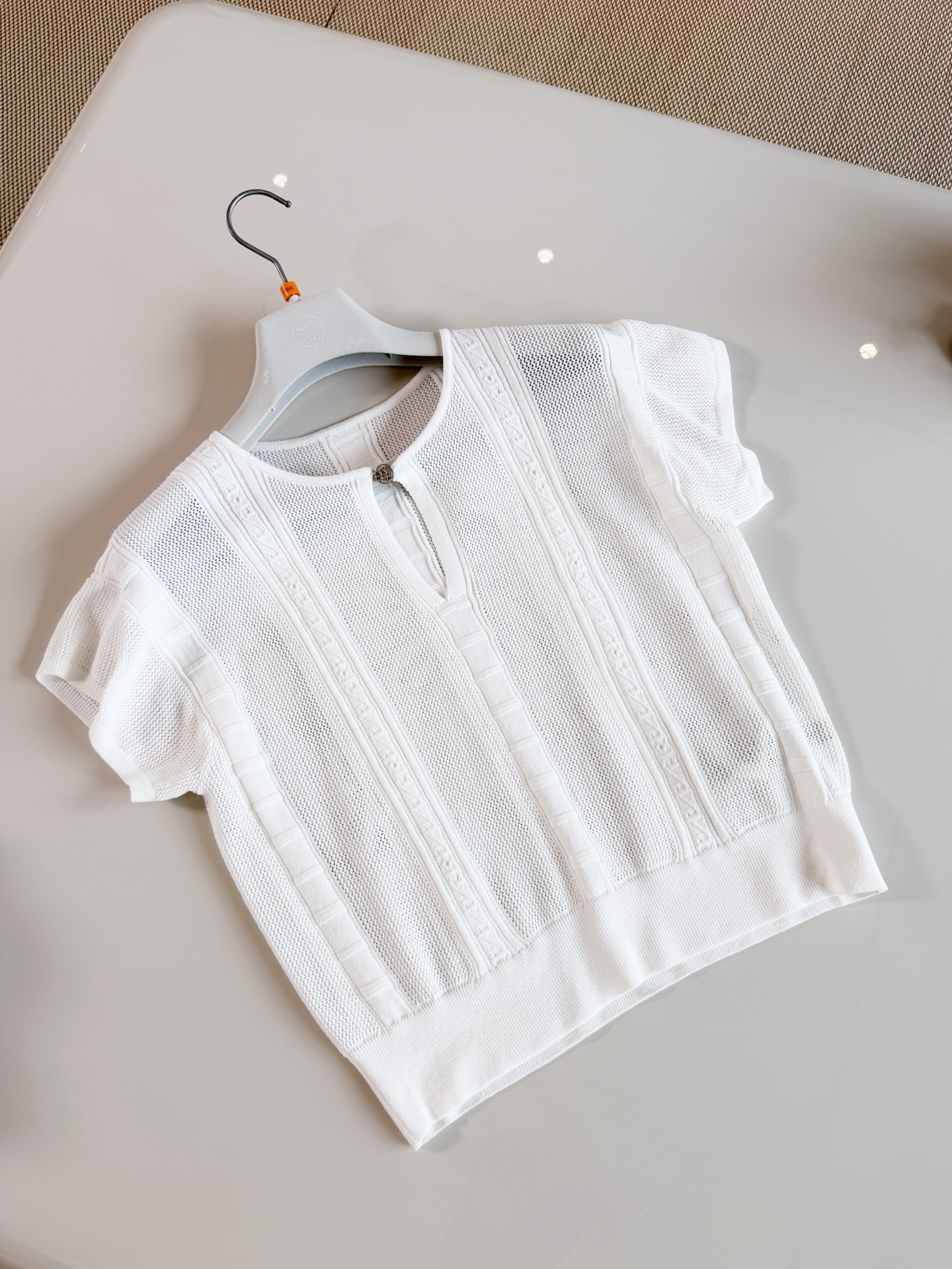 NO:953645,HER 26S Hollow embossed jacquard V-neck stretch knitted T-shirt. The jacquard T-shirt is made of knitting technology. The V-neck is embellished with buttons. The body is covered with vertical strips of hollow jacquard texture. The version is short and slightly loose. The jacquard concave and convex lines are clear. Top quality for sale, tees, t-shirt,19860909HER 26S 镂空浮雕提花V领弹力针织T恤 提花T恤采用针织工艺制作而成 V领点缀纽扣设计 衣身满布竖条镂空提花纹理,版型短款微宽松 提花凹凸纹路清晰 顶级品质发售,,tees，t-shirt,,Women's clothing