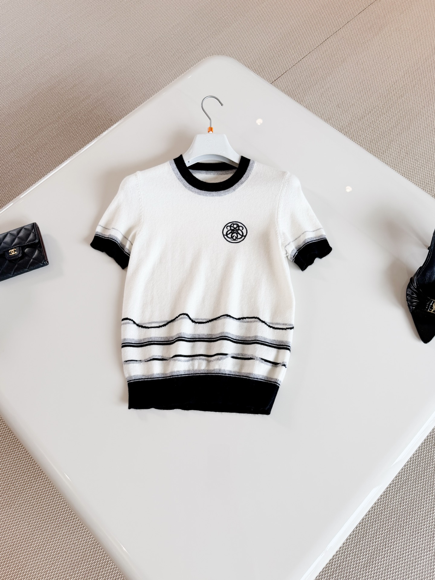 NO:956763,HER 26S Black and white contrasting wavy pattern embroidered badge sweater. Striped knitted short sleeves. Made of cashmere knitting. The body has black and white contrasting wavy stripes. Black and gray lines gently undulate on a beige base. Stretch slim fit. Top quality for sale. T-shirt.19860909HER 26S 黑白撞色波浪纹刺绣徽章针织衫 条纹针织短袖 采用山羊绒材质针织制作而成 衣身有黑白撞色的波浪形条纹,黑色和灰色线条在米色底上轻轻起伏 弹力修身版型 顶级品质发售,,T-shirt,,Women's clothing