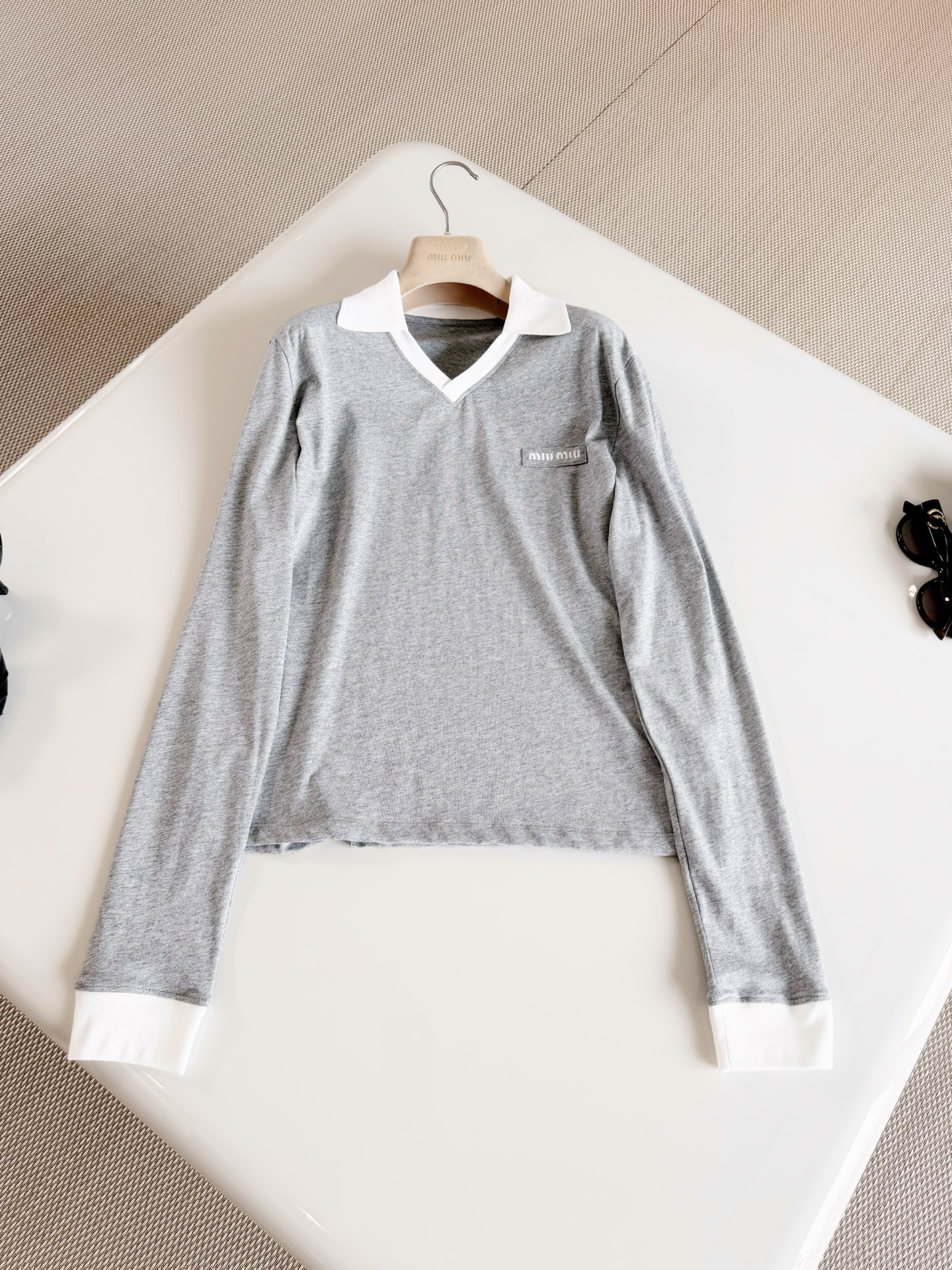 NO:956717,MIU 26S Gray and white contrasting lapel V-shaped cotton long-sleeved T-shirt. The T-shirt is made of cotton fabric. It feels soft and skin-friendly with moderate elasticity. Classic gray and white contrasting design, white lapel and small V-shaped neckline. Clean and simple. Versatile for daily wear. Top quality,,miumiu,tees,t-shirt,19860909MIU 26S 灰白撞色翻领V型棉质长袖T恤 T恤选用棉质面料制作而成 触感软糯亲肤 弹力适中 经典灰白撞色设计,白色翻领小V型领口 利落简约 日常穿搭百搭 顶级品质,,miumiu,tees，t-shirt,,Women's clothing
