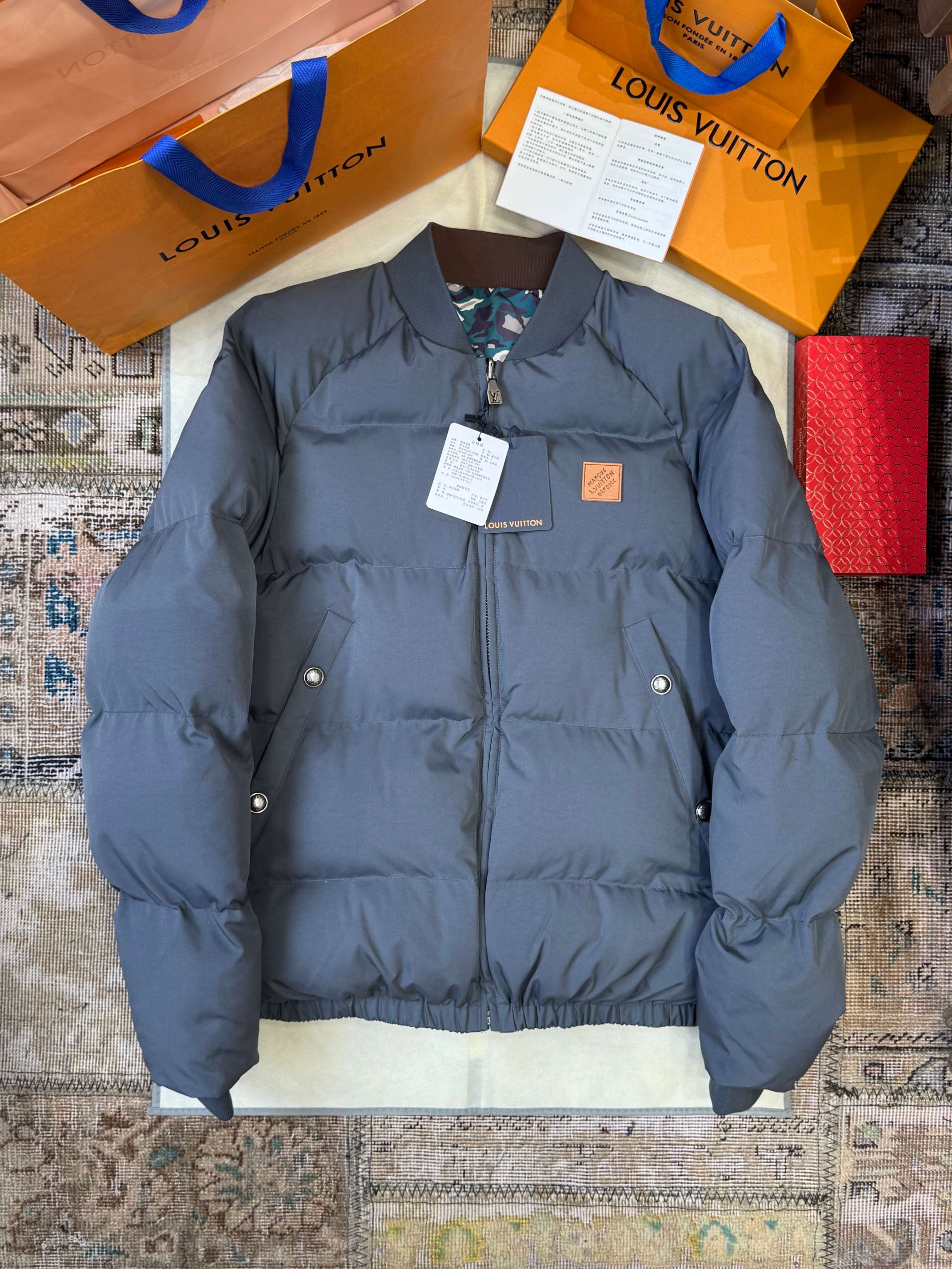 NO:645417,LOUIS VUITTON Louis Vuitton leather label camouflage double-sided cotton jacket ——————  It uses 90% white duck down as the filling, which has excellent thermal insulation performance and light texture. When you brush the surface with your fingers, you can feel the fluffy down rebounding as light as a cloud. It not only provides excellent thermal insulation effect, but also ensures a comfortable wearing experience; the double-sided wearable design has finely processed the fabrics on both sides, and one side is full of high-end feel.  The matte matte material has a delicate texture and color that is calm and low-key through a special coating and treatment process. The other side is a vibrant bright reflective material, which uses the ingenious idea of hiding the flesh and making the body slimmer. The dropped shoulder design weakens the shoulder line through precise tailoring, making the shoulder line look softer and more natural, while also modifying the deficiencies of the shoulder.  ————————8886088 Material: duck down Loose fit Color camouflage Size M-3XL,,louis vuitton,louis vuitton,down jacket,alexander wang19860909LOUIS VUITTON路易威登皮标迷彩双面棉服 ——————— 采用90白鸭绒作为填充物,具有极佳的保暖性能和轻盈质感,手指拂过表层能感受到蓬松的羽绒如云朵般轻盈回弹,不仅提供了卓越的保暖效果,还保证了穿着的舒适体验;双面可穿的设计对两面的面料进行了精细处理,一面是高级感十足的哑光雾面材质,通过特殊的涂层和处理工艺,使其质感细腻色泽沉稳低调,另一面是活力四射的亮面反光材质,运用了反了藏肉显瘦的巧思.落肩设计通过精确的剪裁弱化肩线,使得肩部线条看起来更加柔和自然,同时也能修饰肩部的不足. ————————8886088 材质: 鸭绒 版型宽松 颜色迷彩 尺码M-3XL,,louis vuitton,louis vuitton,down jacket,alexander wang,Men's clothing