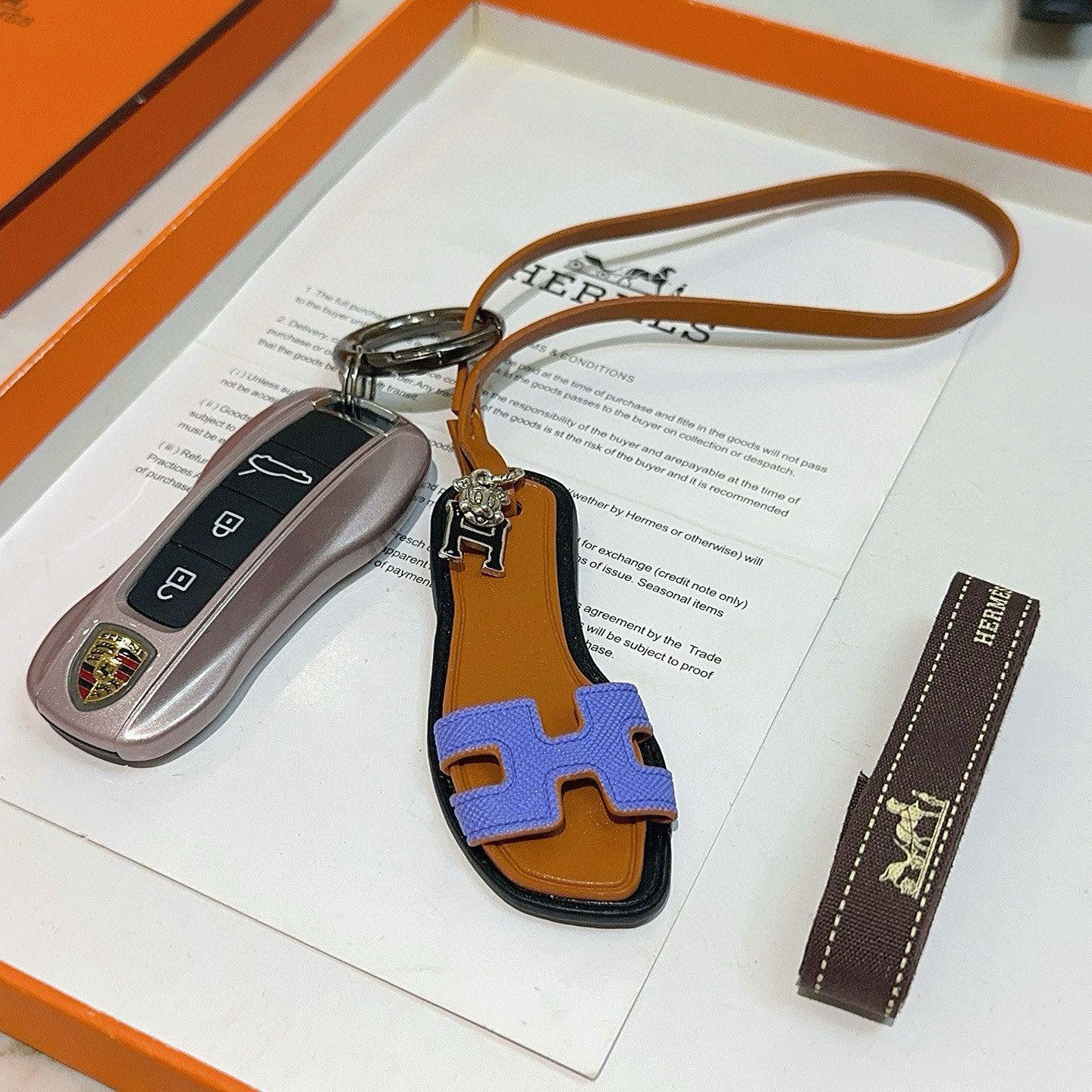 Hermes Oran Sandal Charm pendant tan leather black trim lavender purple H strap silver tone metal hardware 17cm lanyard length