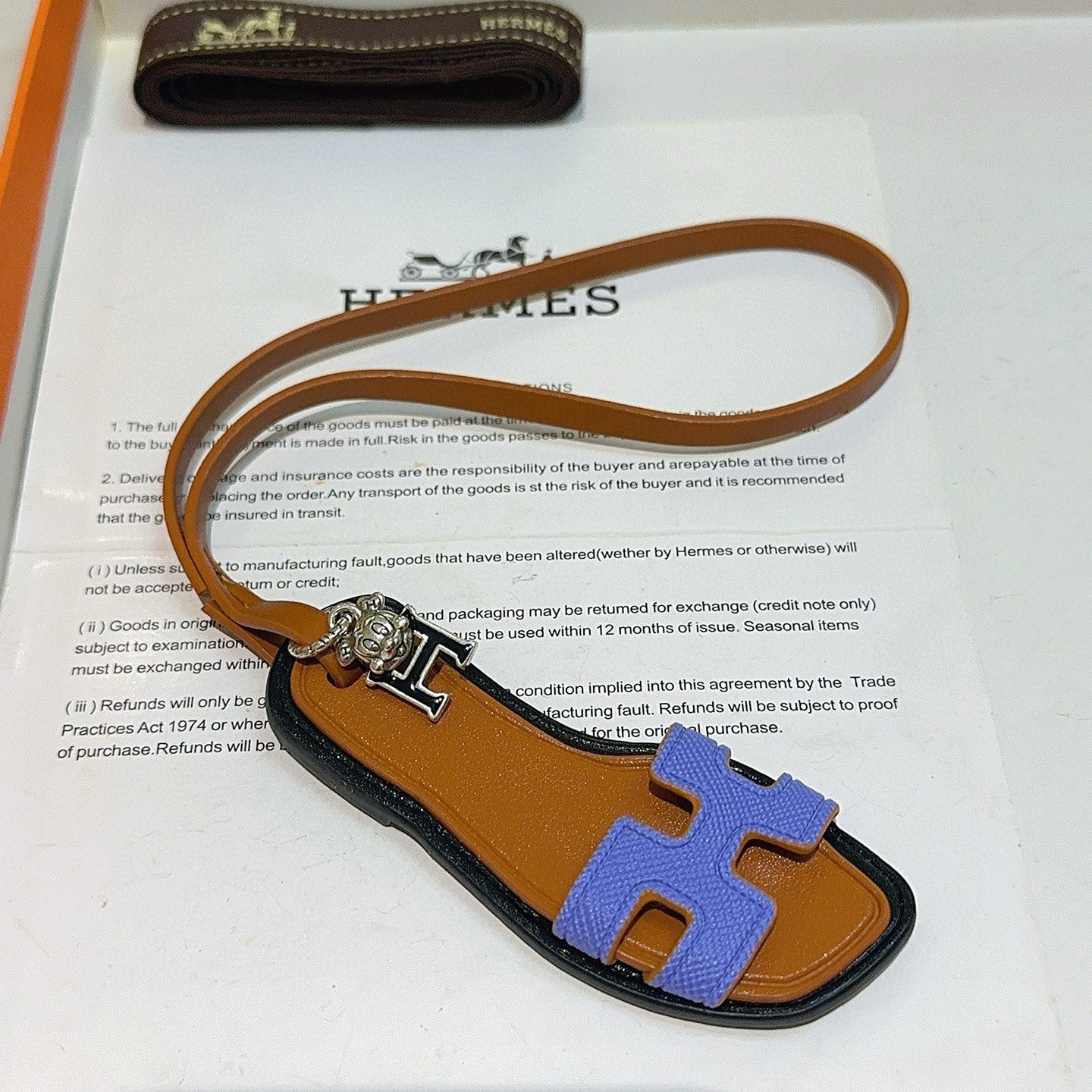 Hermes Oran Sandal Charm pendant tan leather black trim lavender purple H strap silver tone metal hardware 17cm lanyard length