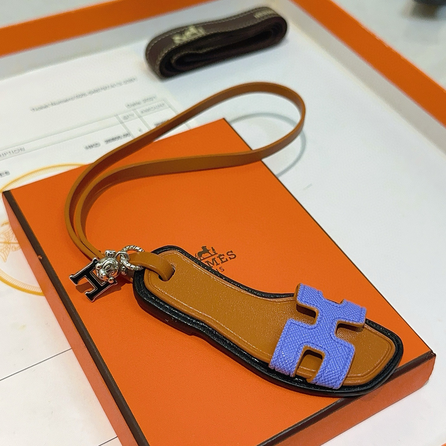 Hermes Oran Sandal Charm pendant tan leather black trim lavender purple H strap silver tone metal hardware 17cm lanyard length