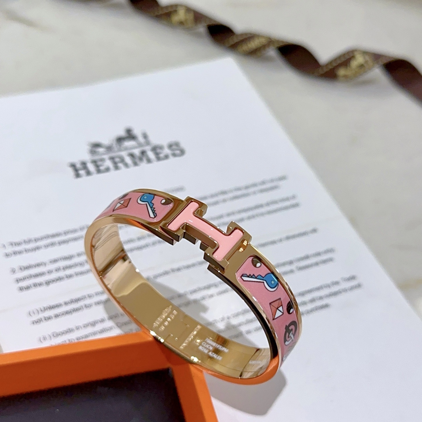 Pulseira Hermes Clic Clac H em metal banhado a ouro rosa com esmalte rosa com chave multicolorida e motivos de fechadura PM