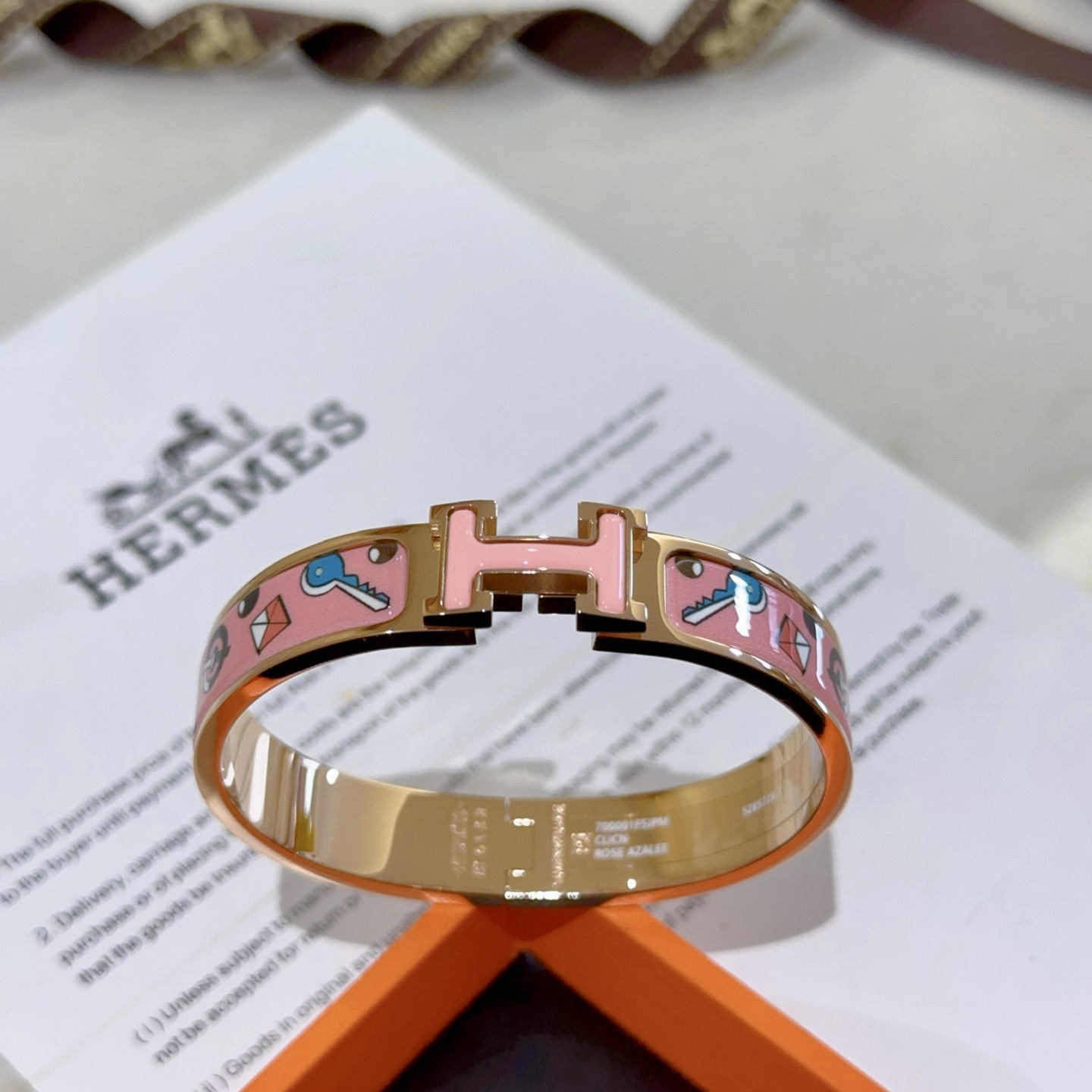 Pulseira Hermes Clic Clac H em metal banhado a ouro rosa com esmalte rosa com chave multicolorida e motivos de fechadura PM
