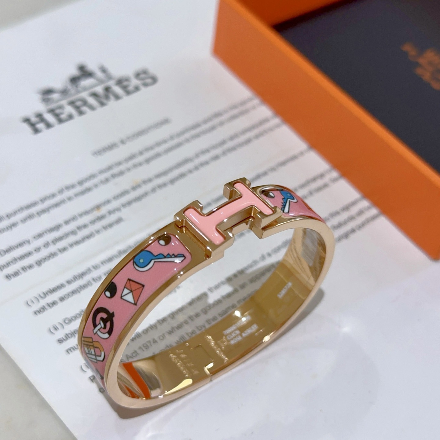 Pulseira Hermes Clic Clac H em metal banhado a ouro rosa com esmalte rosa com chave multicolorida e motivos de fechadura PM