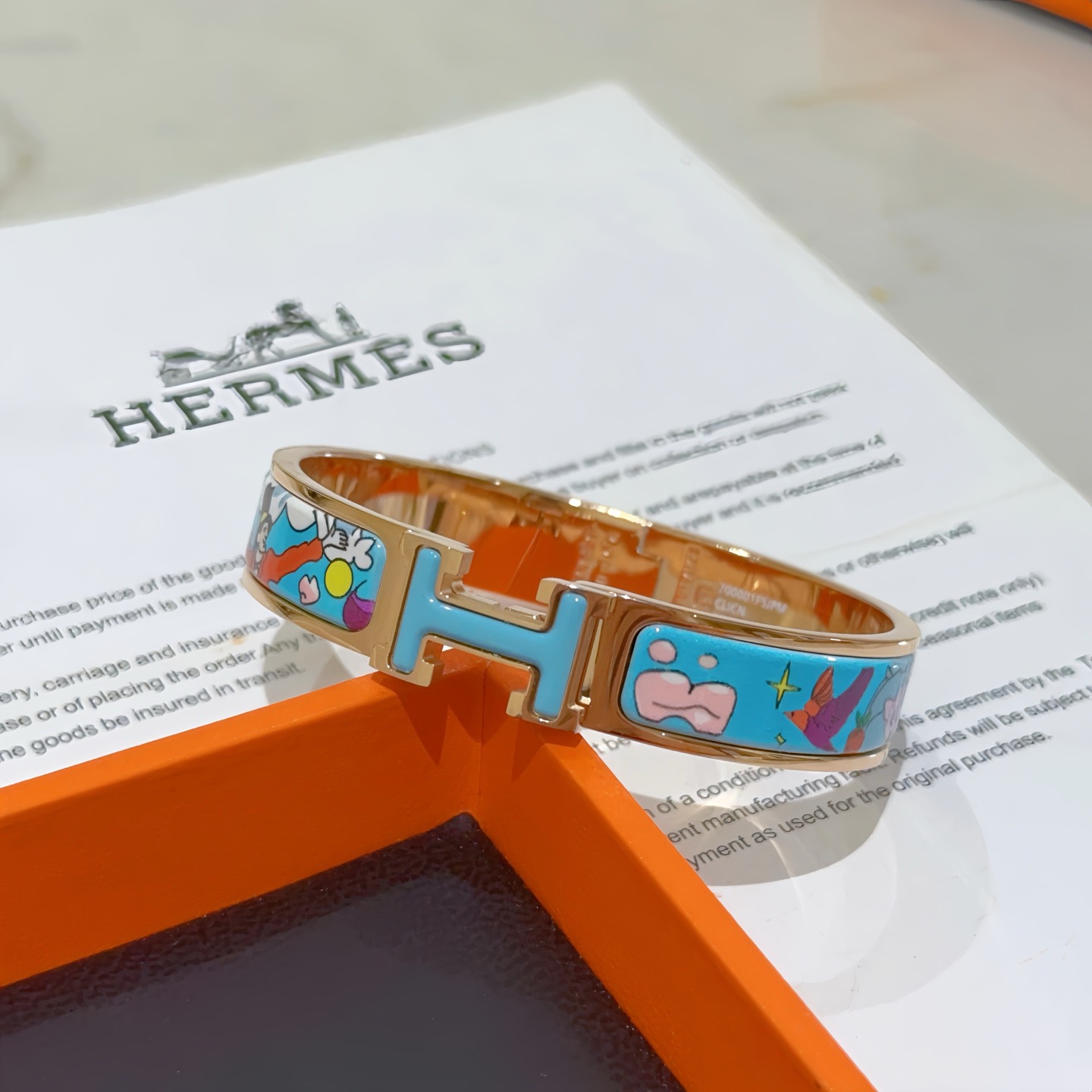Hermes Clic Clac H bracelet Rose gold plated metal with light blue enamel featuring multicolor cartoon print PM