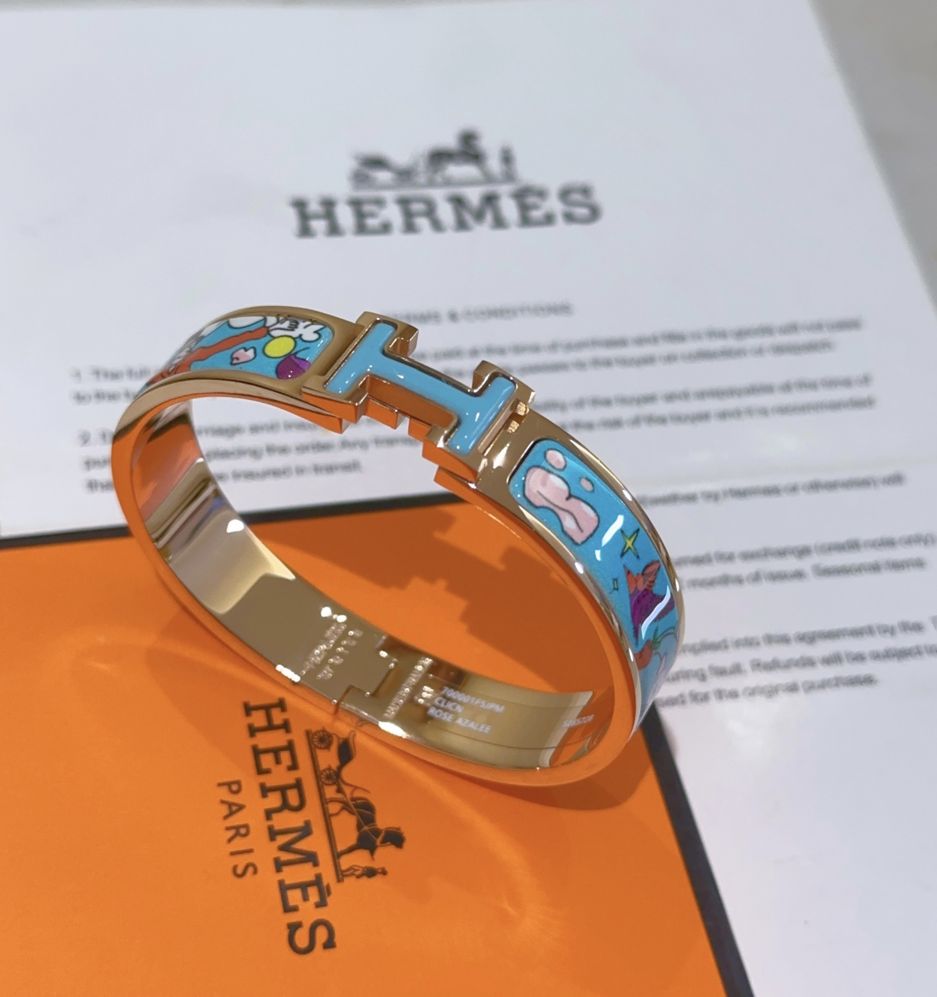 Pulsera Hermes Clic Clac H de metal chapado en oro rosa con esmalte azul claro y estampado de dibujos animados multicolor PM