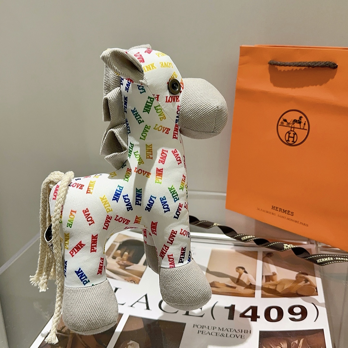 Hermes Rodeo Pegase Horse Charm pendant White fabric with multicolor LOVE and PINK text print light gray corduroy accents cream rope tail brass-toned metal eye detail 25cm