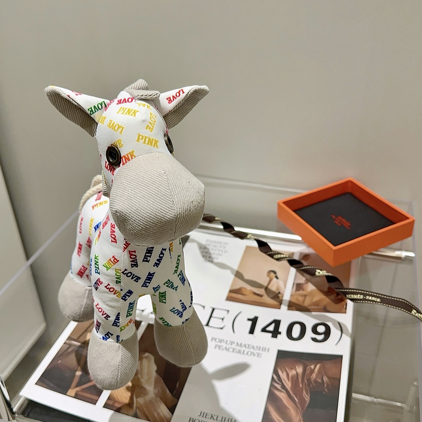 Hermes Rodeo Pegase Horse Charm pendant White fabric with multicolor LOVE and PINK text print light gray corduroy accents cream rope tail brass-toned metal eye detail 25cm