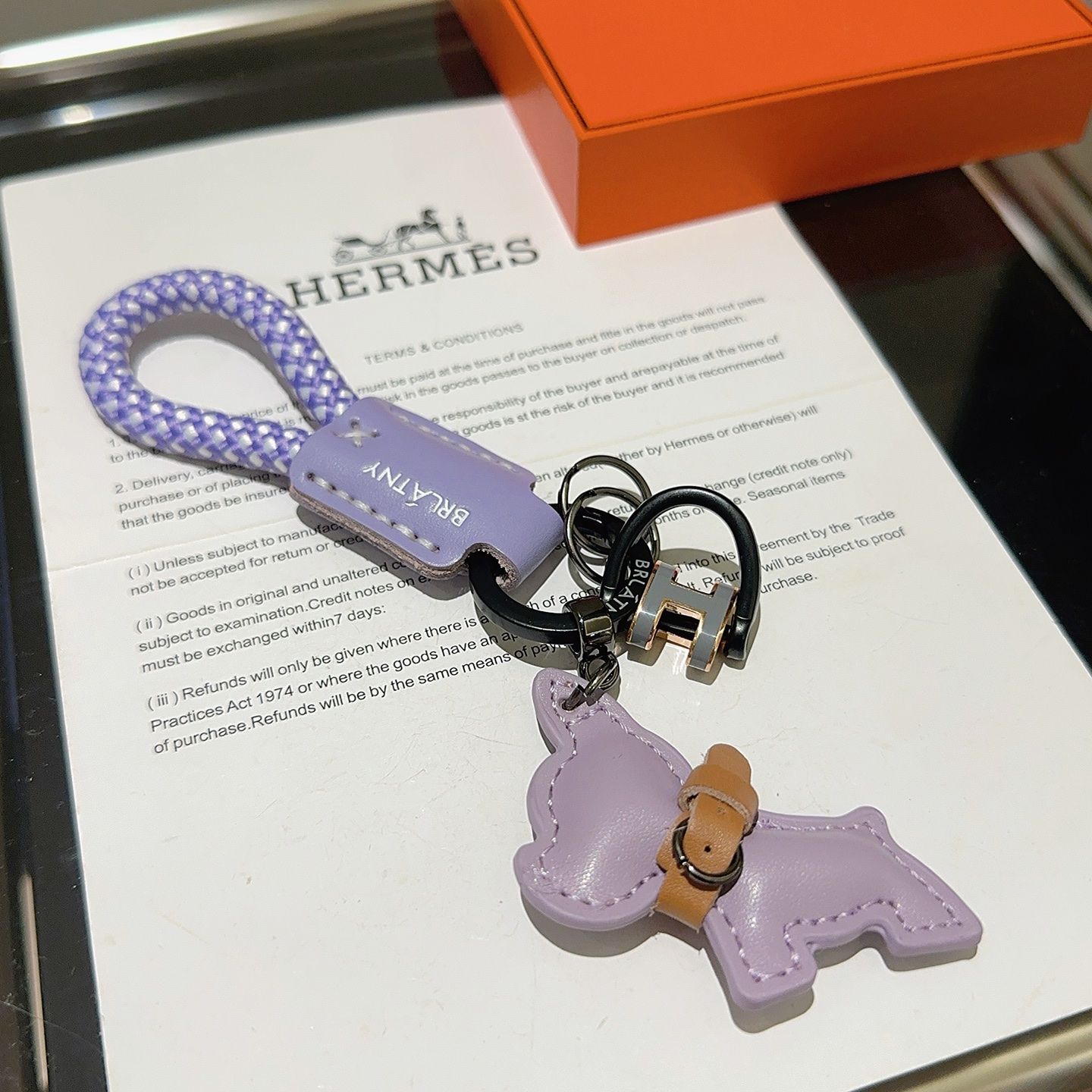 Hermes H Logo Bulldog Charm Porte-clés pendentif Cuir violet lavande accent cuir marron cordon tressé violet et blanc bronze à canon matériel noir or rose et gris Breloque logo H 10 cm longueur totale