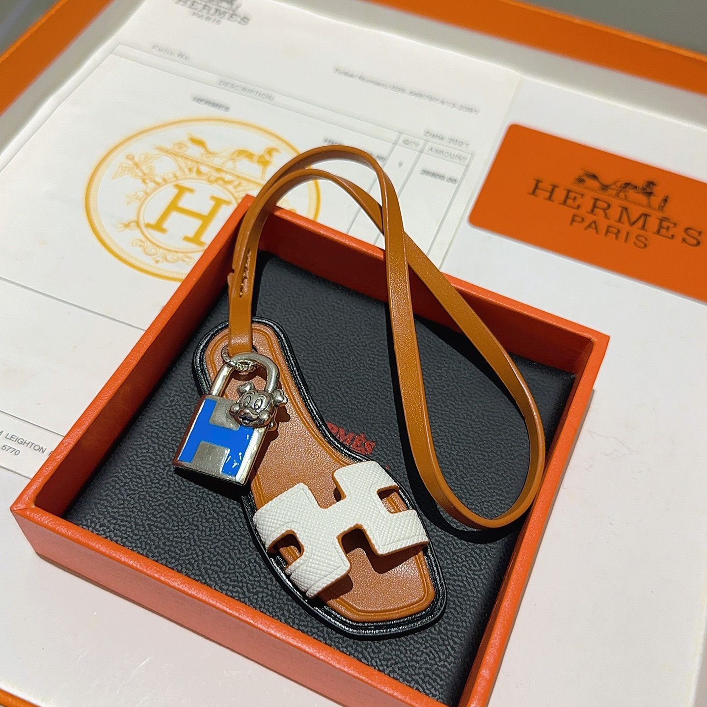 Hermes Oran Sandal Charm pendant tan leather white Epsom leather silver-tone metal blue enamel black edge trim 12cm strap length
