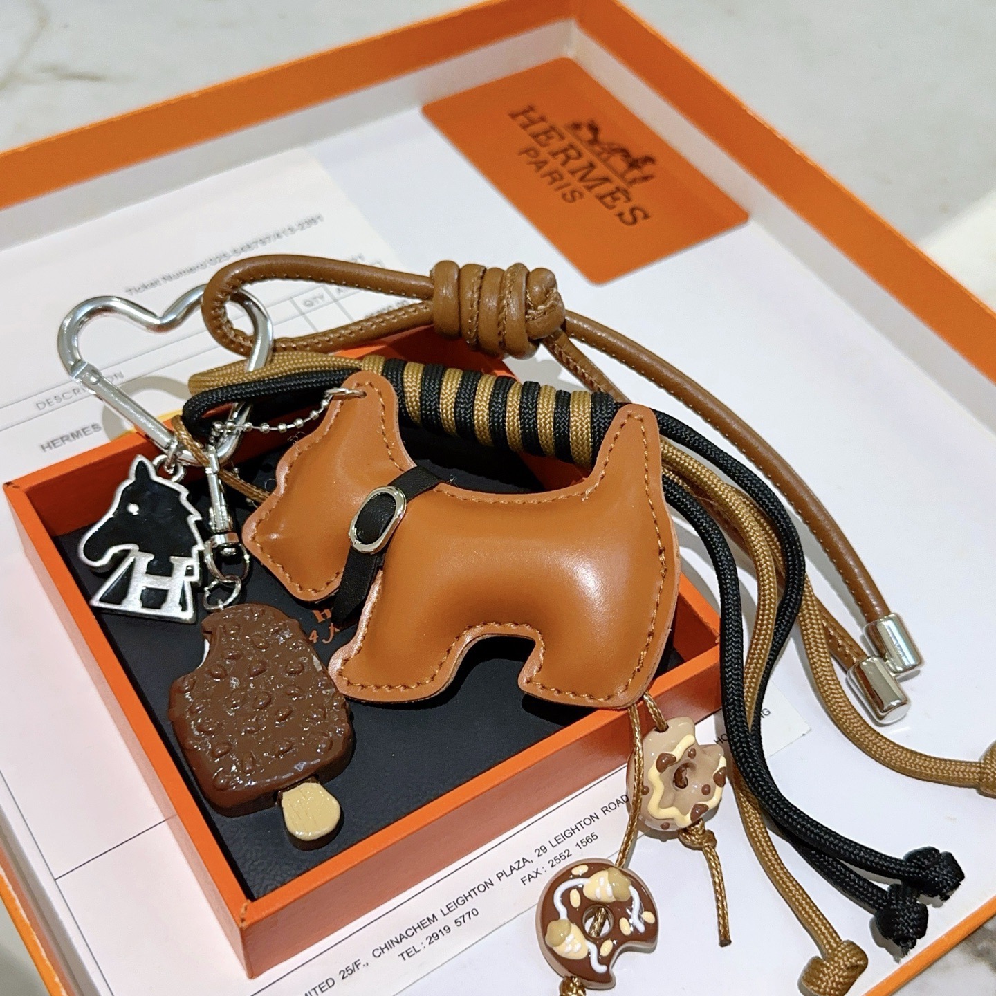 Hermes Scottie Dog Charm Keychain pendant tan leather silver-tone metal black enamel brown and beige dessert-themed charms black and tan woven cord 15cm total strap length