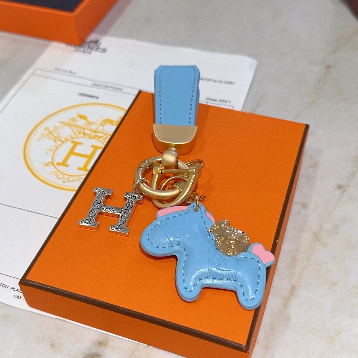 Hermes Rodeo Horse H Logo Key Charm pendant Light blue leather matte gold hardware silver-tone H charm pink accent details 8cm total length