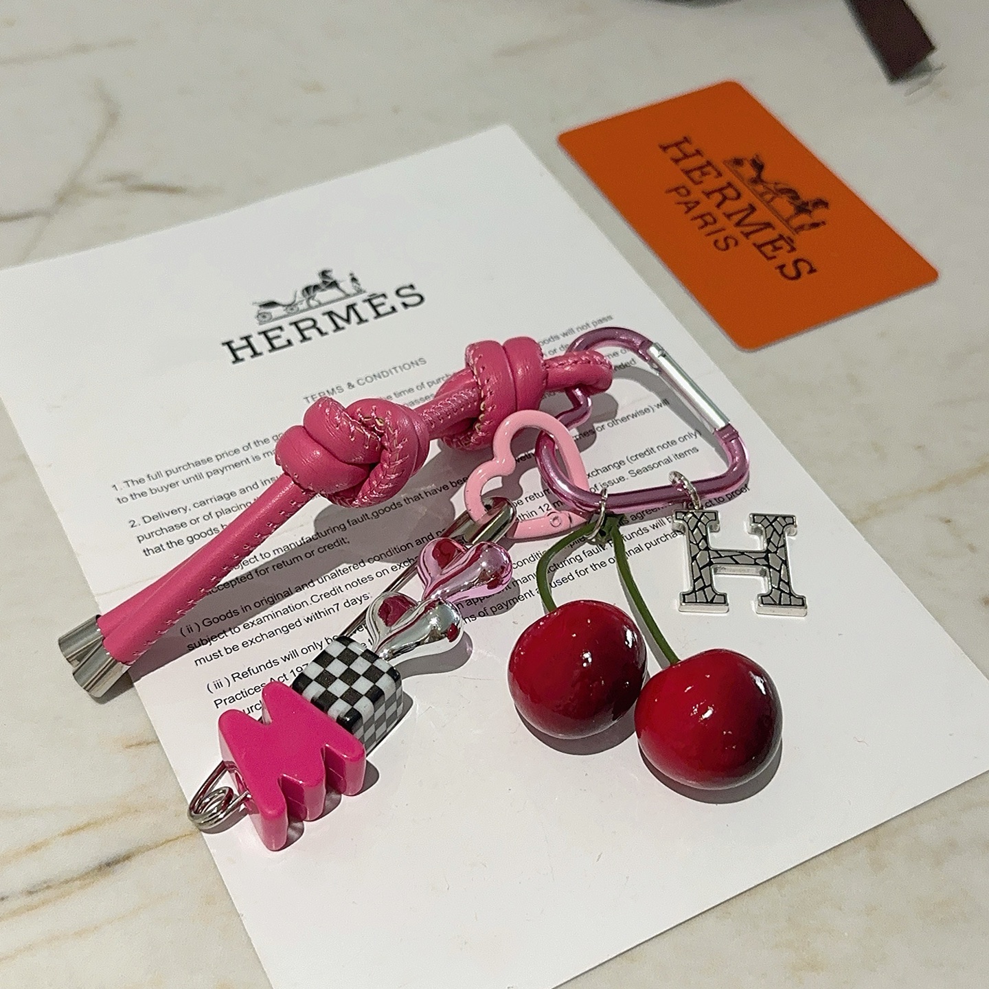 Hermes Cherry H Logo Knot Bag Charm Keychain pendant Hot pink leather silver-tone metal red cherry accents black and white checkered detail pink heart hardware green cherry stems 10cm