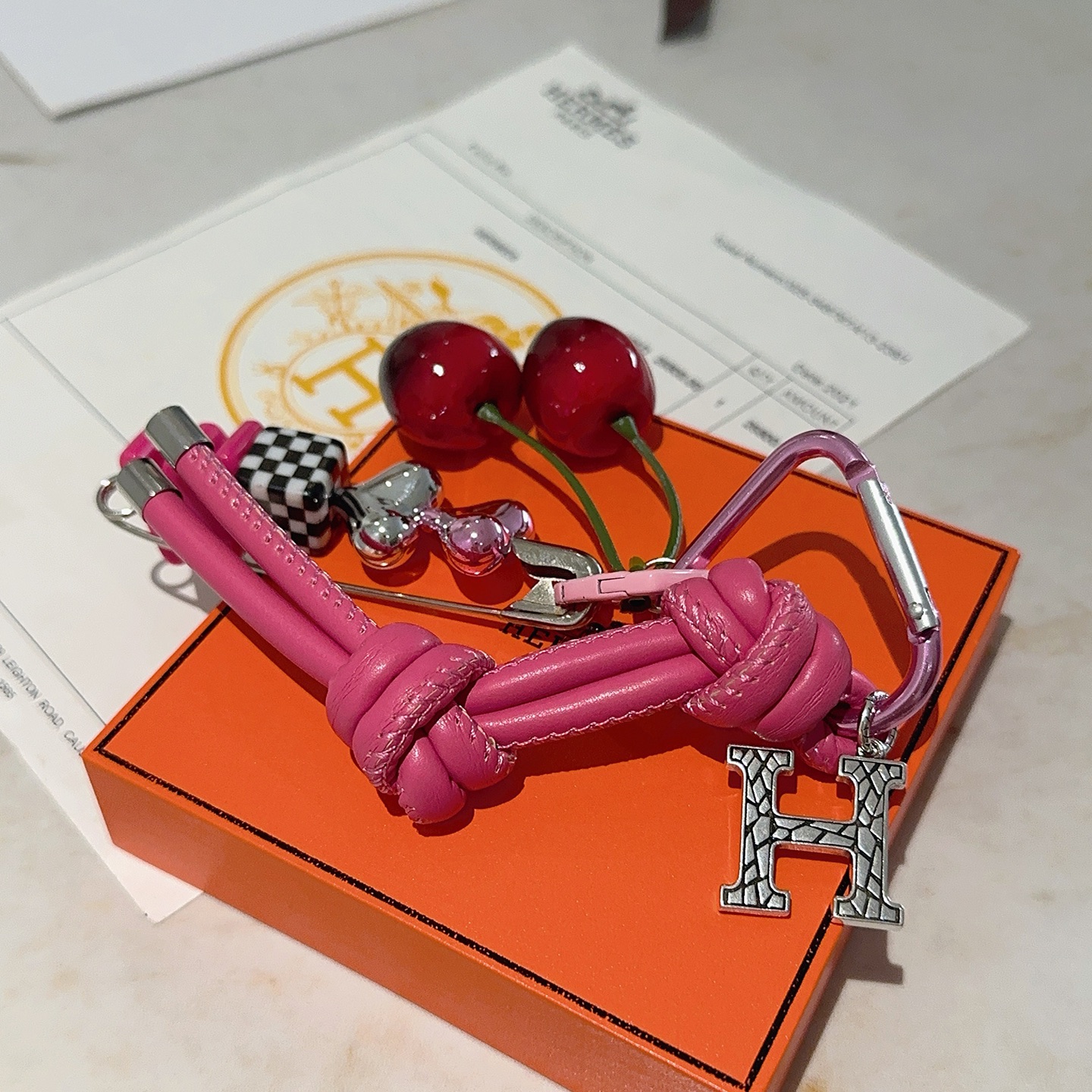 Hermes Cherry H Logo Knot Bag Charm Keychain pendant Hot pink leather silver-tone metal red cherry accents black and white checkered detail pink heart hardware green cherry stems 10cm