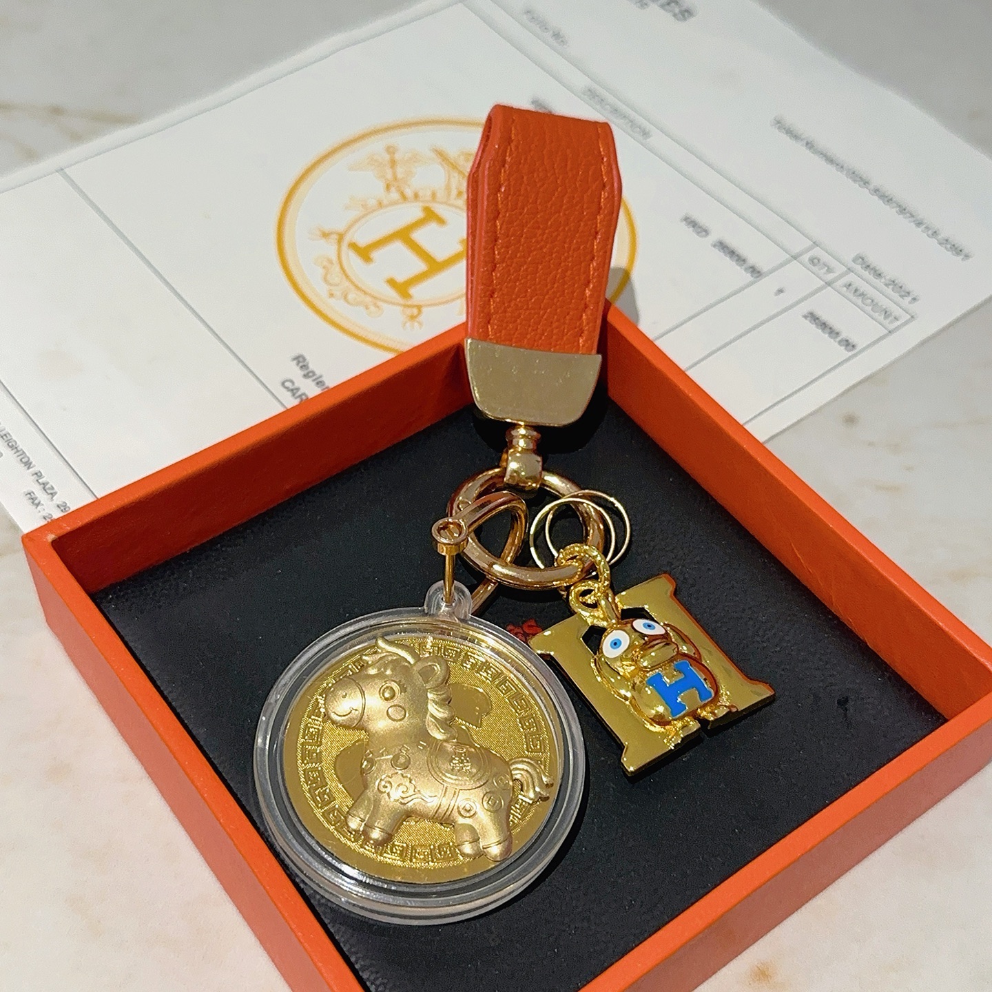 Hermes H Logo Medallón de Caballo Llavero colgante Cuero naranja metal dorado esmalte azul medallón de oro 10 cm de longitud total