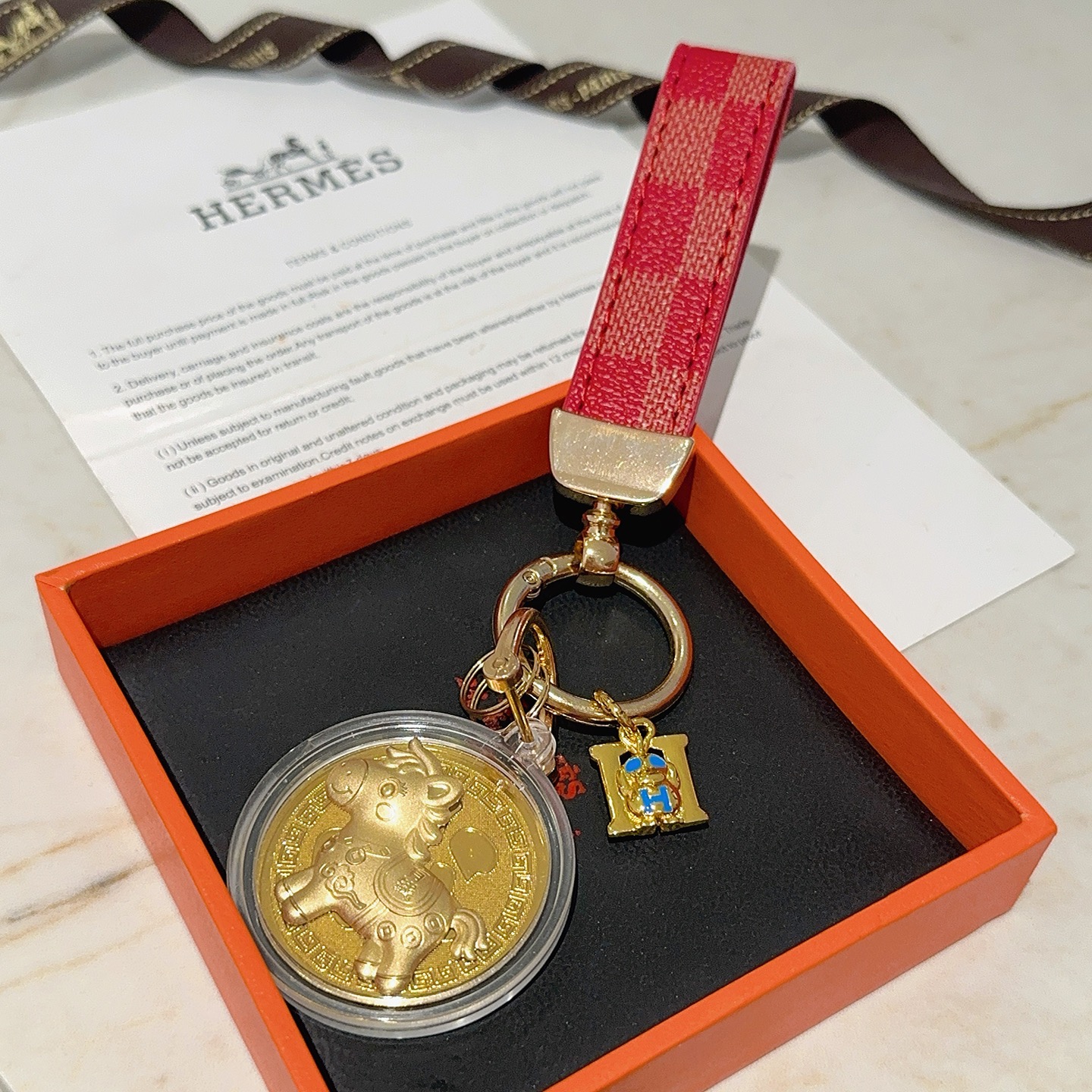Pendentif porte-clés Hermes Lucky Horse Fu Charm Bracelet en toile enduite à carreaux rouges Quincaillerie en métal doré Médaillon doré en émail bleu Breloque H boîtier de médaillon de protection transparent 10 cm de longueur totale