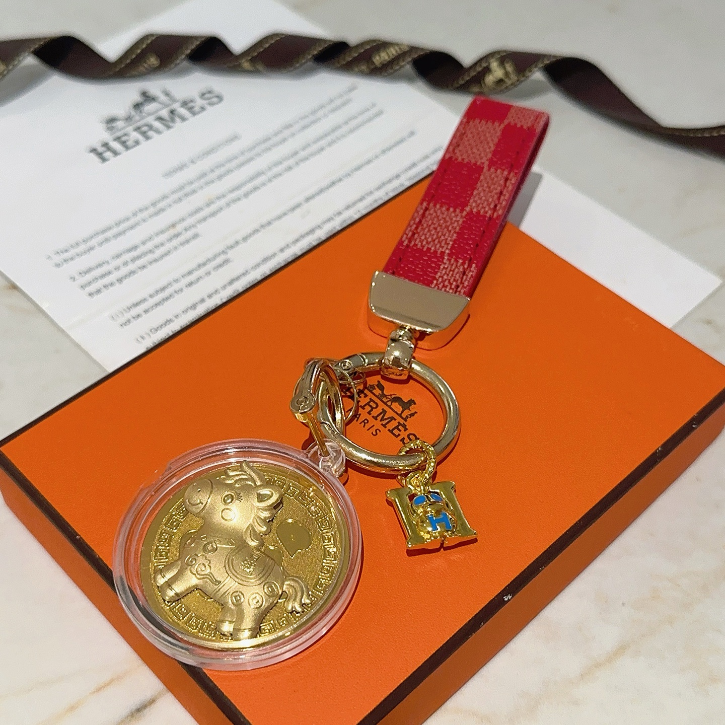 Pendentif porte-clés Hermes Lucky Horse Fu Charm Bracelet en toile enduite à carreaux rouges Quincaillerie en métal doré Médaillon doré en émail bleu Breloque H boîtier de médaillon de protection transparent 10 cm de longueur totale