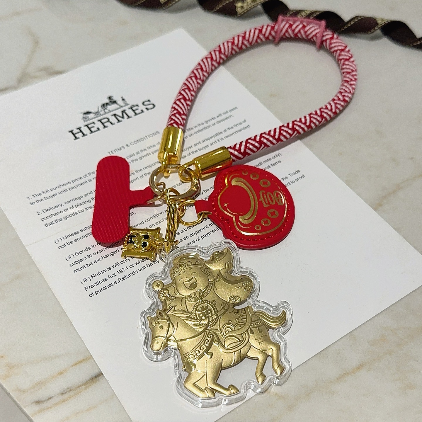 Hermes Get Rich God of Wealth on Horse Key Charm pingente Cordão trançado vermelho e branco metal dourado couro vermelho invólucro acrílico transparente folha de ouro detalhando 18 cm de comprimento da alça de pulso