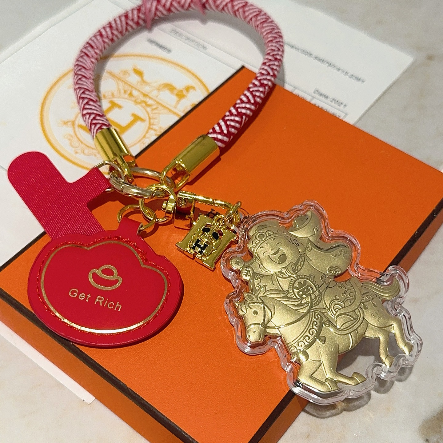 Hermes Get Rich God of Wealth on Horse Key Charm pingente Cordão trançado vermelho e branco metal dourado couro vermelho invólucro acrílico transparente folha de ouro detalhando 18 cm de comprimento da alça de pulso