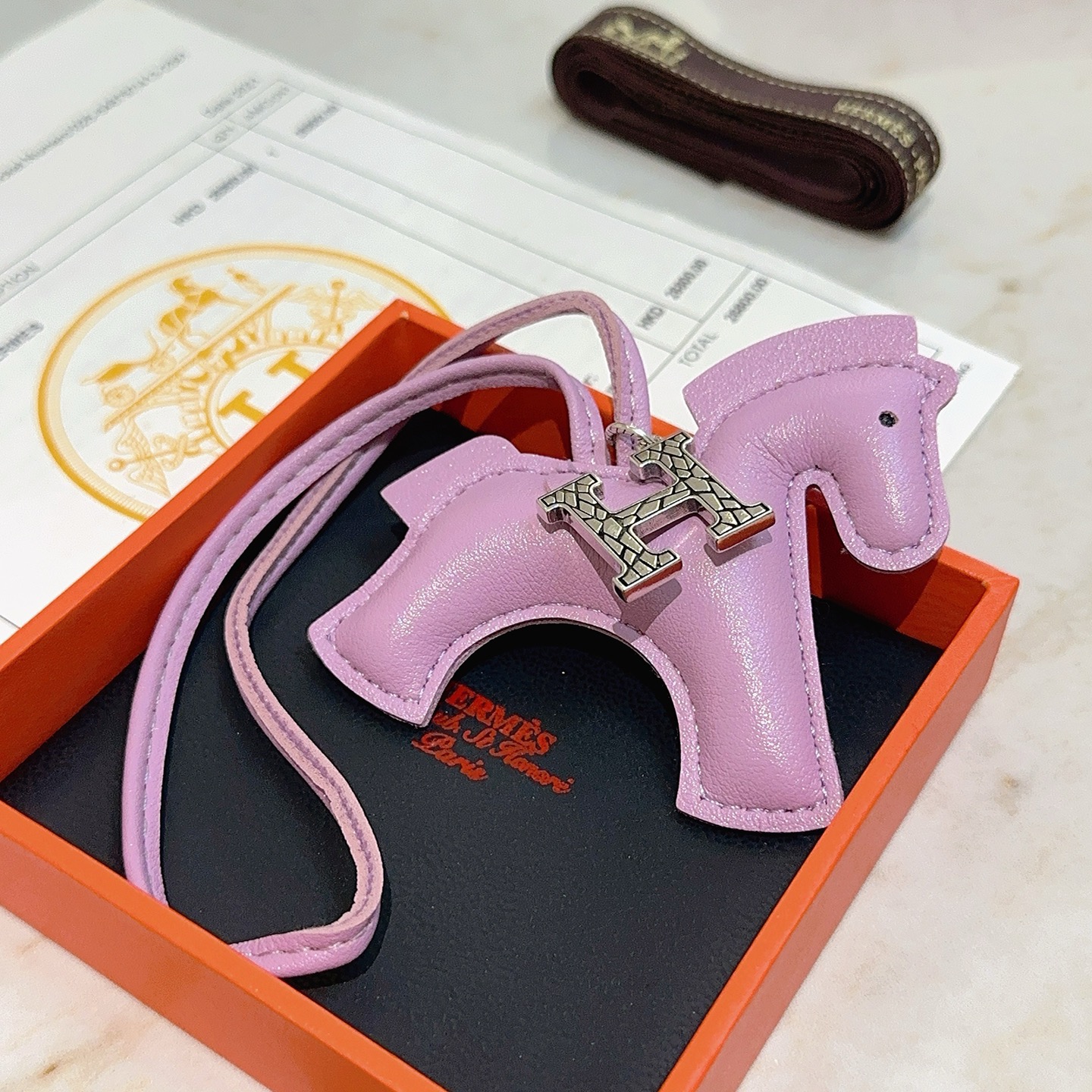 Charme de cavalo Hermes Rodeo Pegase com pingente de logotipo H Mauve Sylvestre couro roxo claro tom prateado textura rachada metal H hardware detalhe de olho preto Charme de 8 cm com pulseira de couro de 12 cm