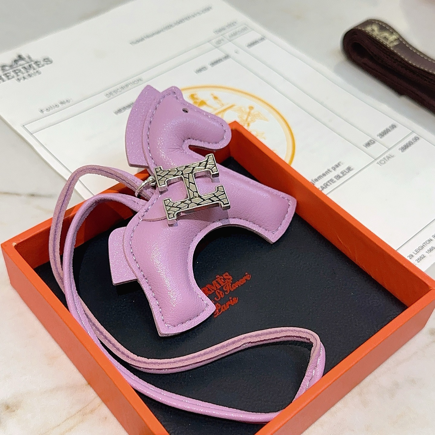Charme de cavalo Hermes Rodeo Pegase com pingente de logotipo H Mauve Sylvestre couro roxo claro tom prateado textura rachada metal H hardware detalhe de olho preto Charme de 8 cm com pulseira de couro de 12 cm