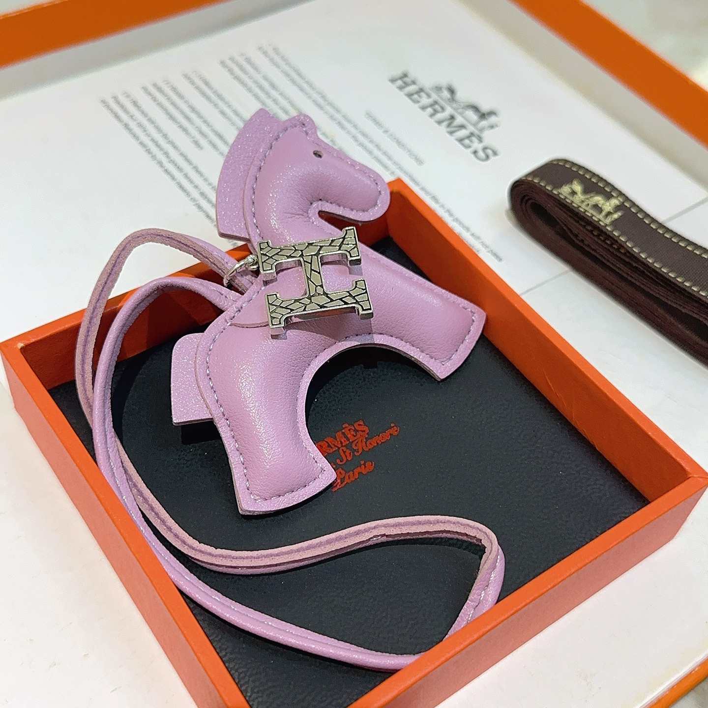Charme de cavalo Hermes Rodeo Pegase com pingente de logotipo H Mauve Sylvestre couro roxo claro tom prateado textura rachada metal H hardware detalhe de olho preto Charme de 8 cm com pulseira de couro de 12 cm
