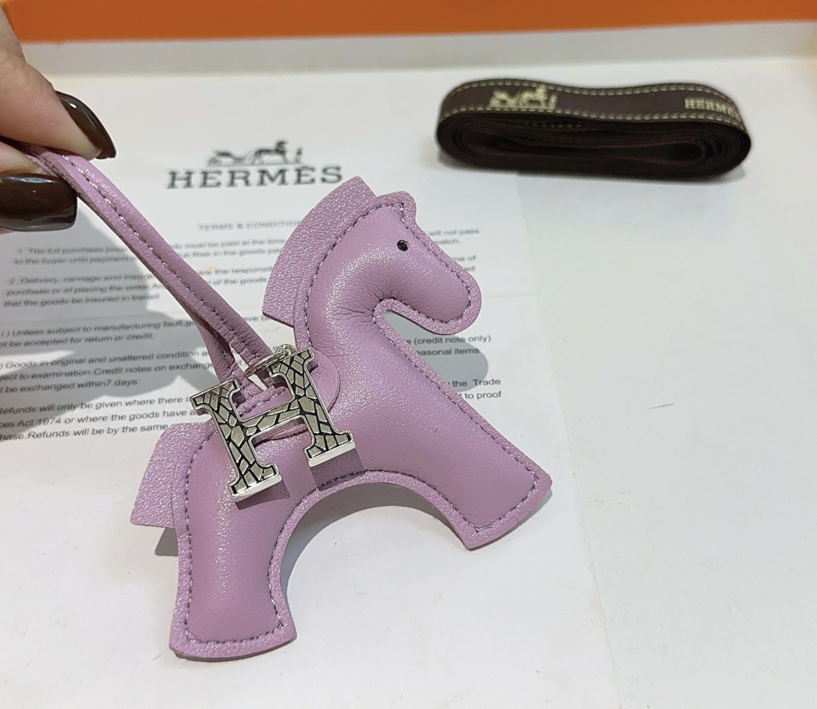 Charme de cavalo Hermes Rodeo Pegase com pingente de logotipo H Mauve Sylvestre couro roxo claro tom prateado textura rachada metal H hardware detalhe de olho preto Charme de 8 cm com pulseira de couro de 12 cm
