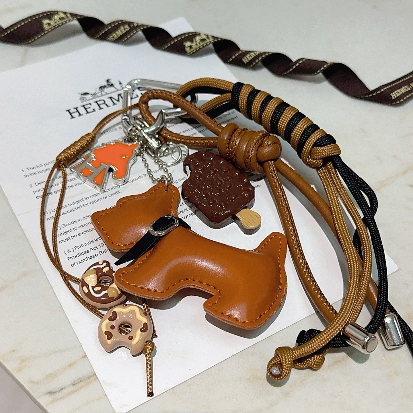 Ciondolo portachiavi Hermes Buddy Dog Charm Metallo argentato pelle marrone chiaro cordone nero e marrone chiaro smalto arancione smalto marrone smalto beige lunghezza totale 12 cm