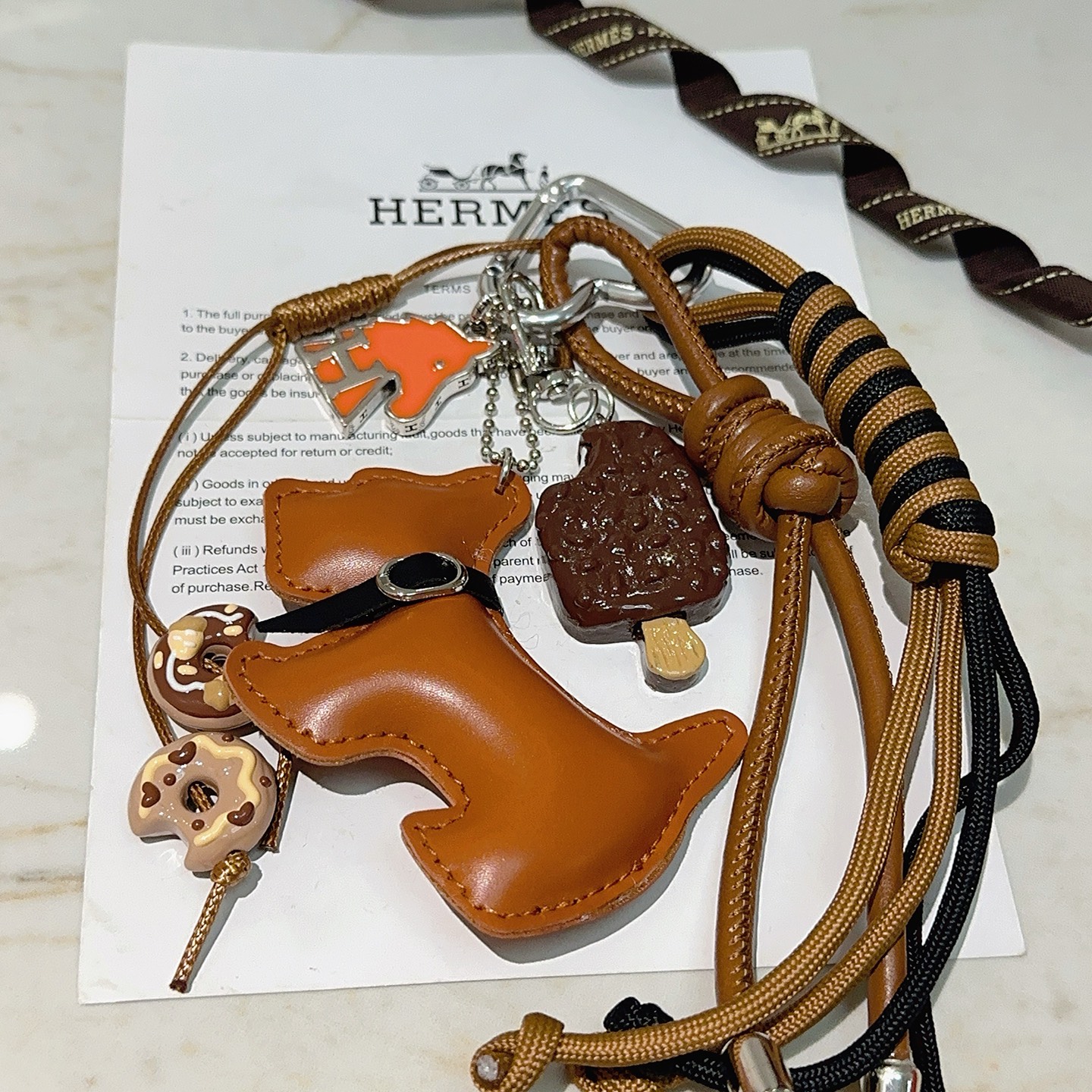 Ciondolo portachiavi Hermes Buddy Dog Charm Metallo argentato pelle marrone chiaro cordone nero e marrone chiaro smalto arancione smalto marrone smalto beige lunghezza totale 12 cm
