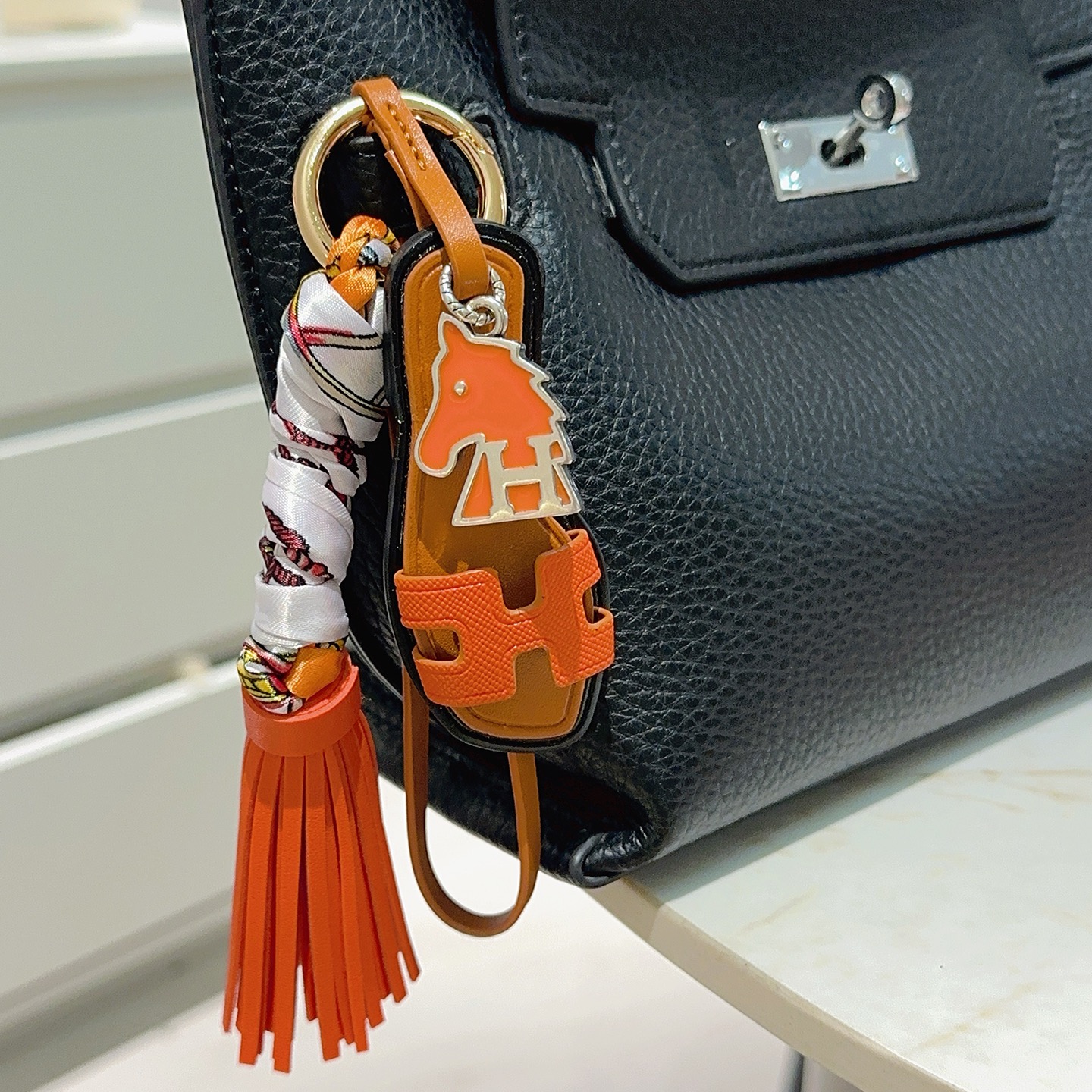 Hermes Oran Sandal Tassel Bag Charm pendant Orange leather tan leather black trim silver-tone metal multicolor printed silk gold-tone hardware 12cm total length
