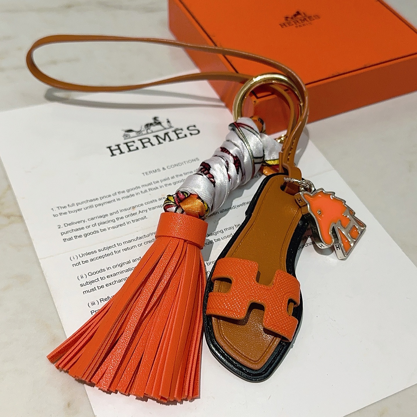 Hermes Oran Sandal Tassel Bag Charm pendant Orange leather tan leather black trim silver-tone metal multicolor printed silk gold-tone hardware 12cm total length