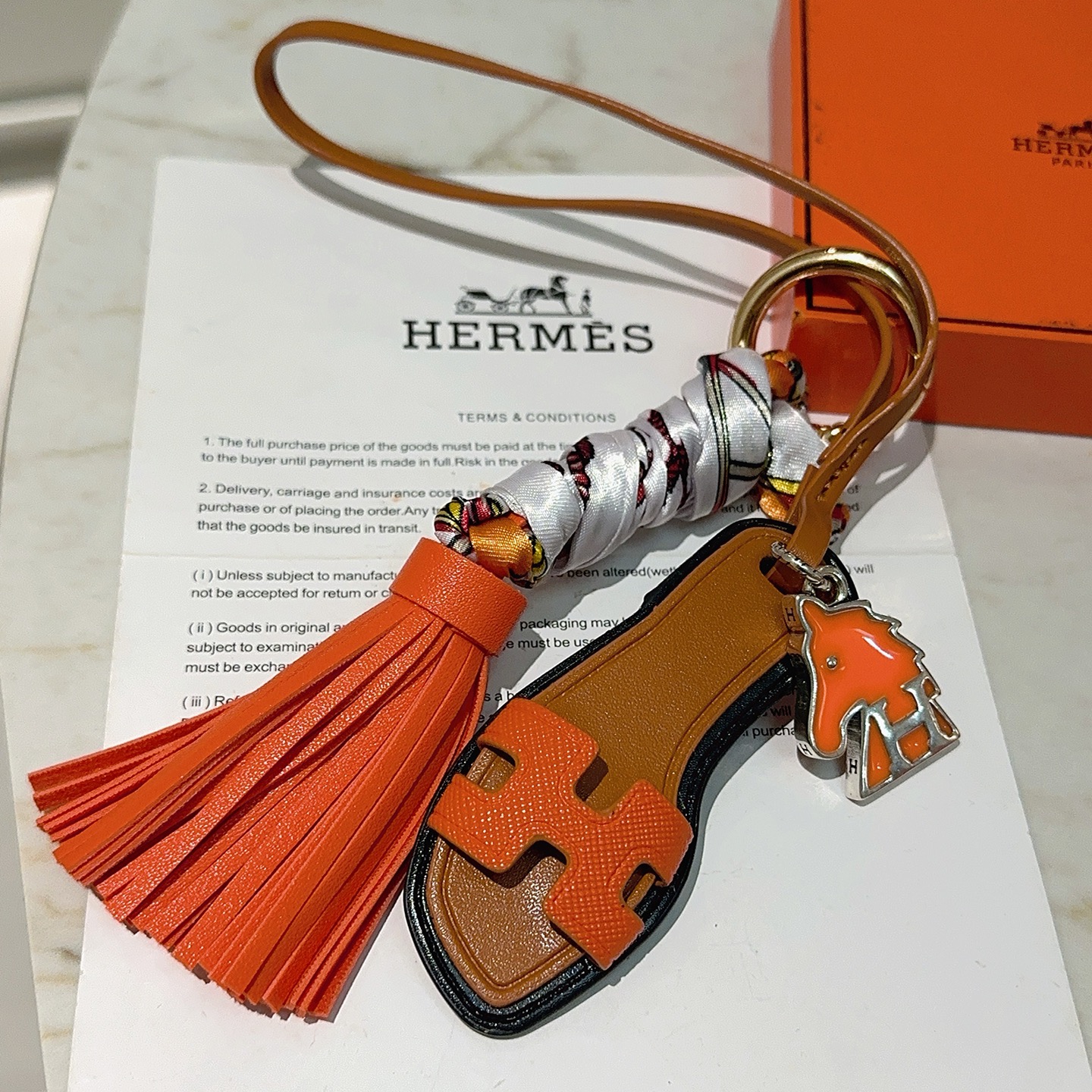 Hermes Oran Sandal Tassel Bag Charm pendant Orange leather tan leather black trim silver-tone metal multicolor printed silk gold-tone hardware 12cm total length