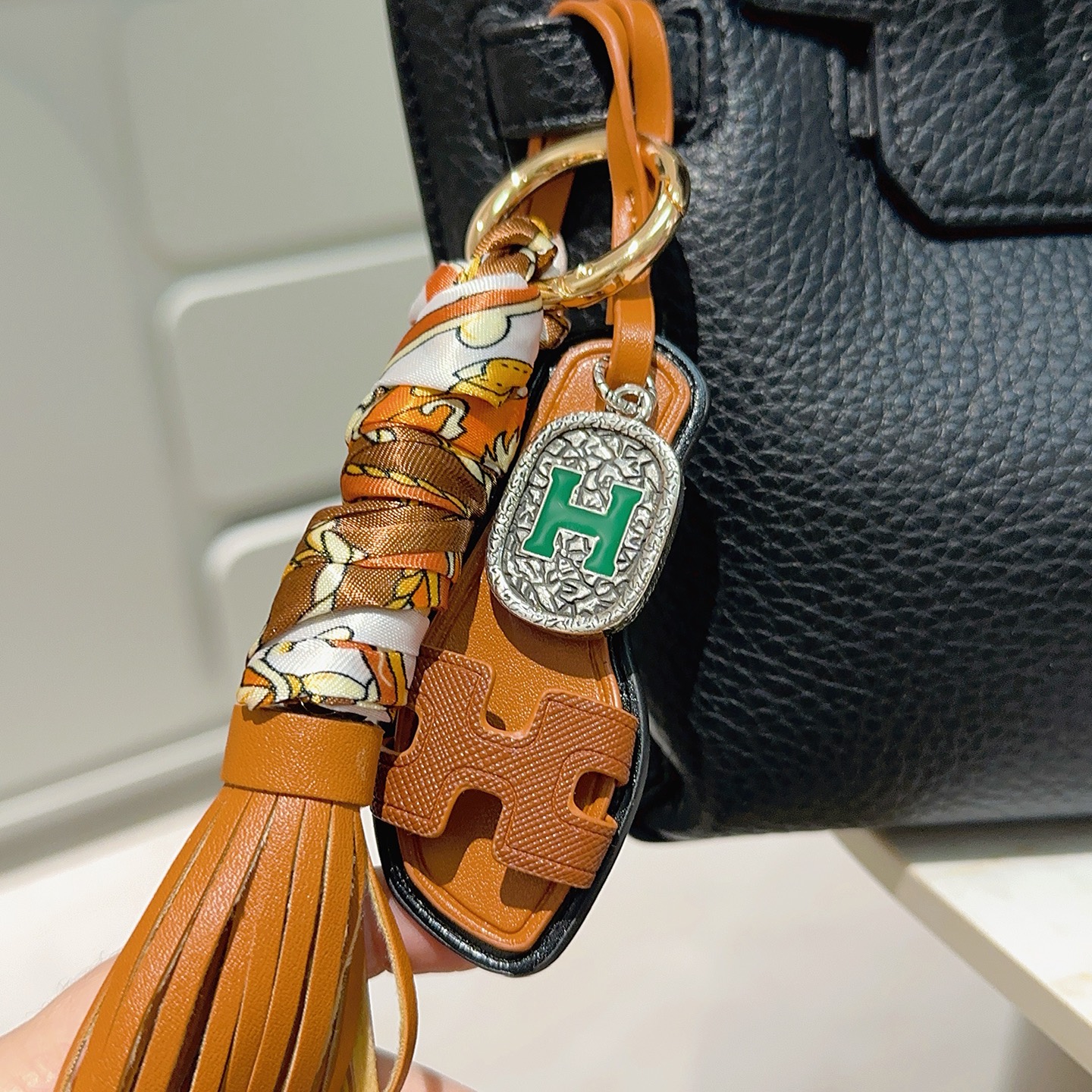 Hermes Oran Sandalo Borsa con nappa Ciondolo con ciondolo Metallo color oro Pelle marrone chiaro Seta stampata multicolore Hardware color argento con dettaglio H in smalto verde Finiture in pelle nera Lunghezza cinturino 18 cm