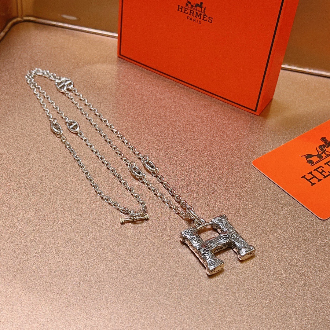 Collier chaîne Hermes H Pendant Farandole Métal argenté avec volutes gravées ne détaillant aucune pierre précieuse supplémentaire 60 cm