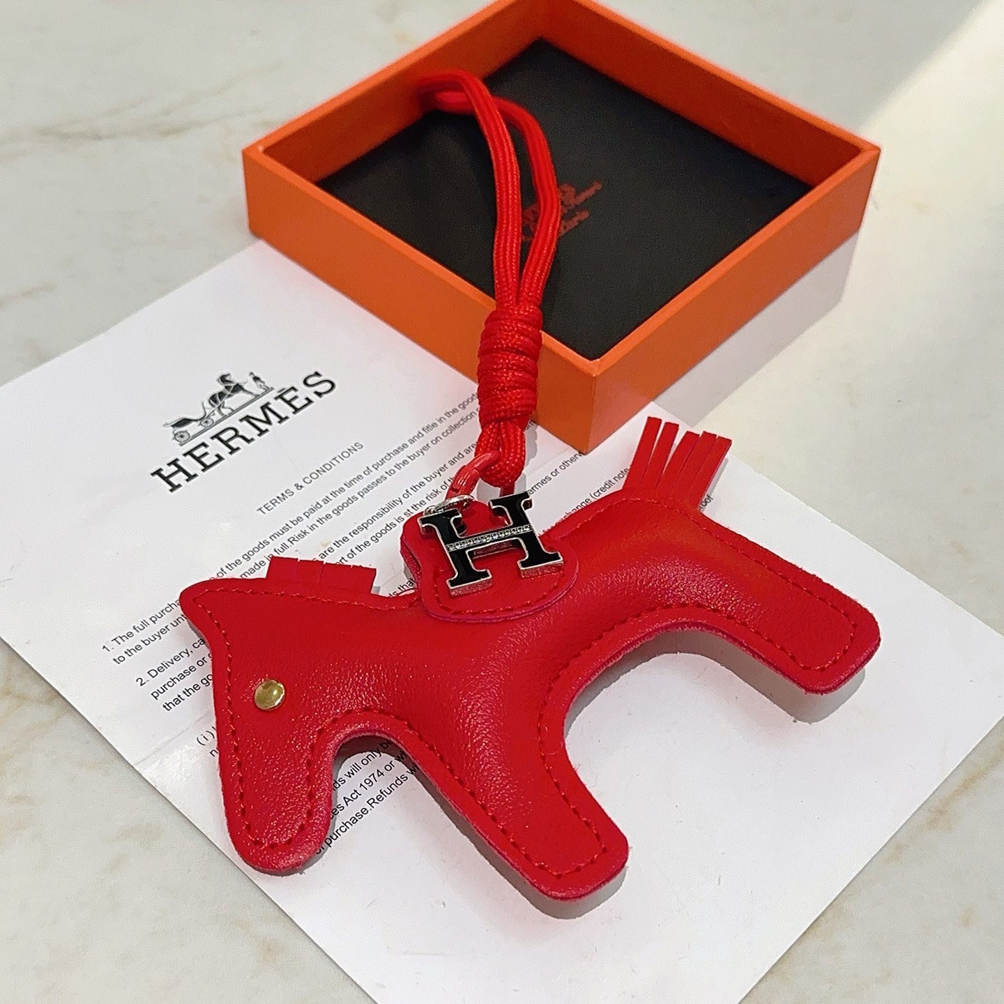 Hermes Rodeo H Logo Horse Bag Charm pendentif Cuir rouge vif métal argenté avec émail noir et détails en cristal transparent clou en œil doré 10 cm longueur totale de la breloque 8 cm cordon attaché