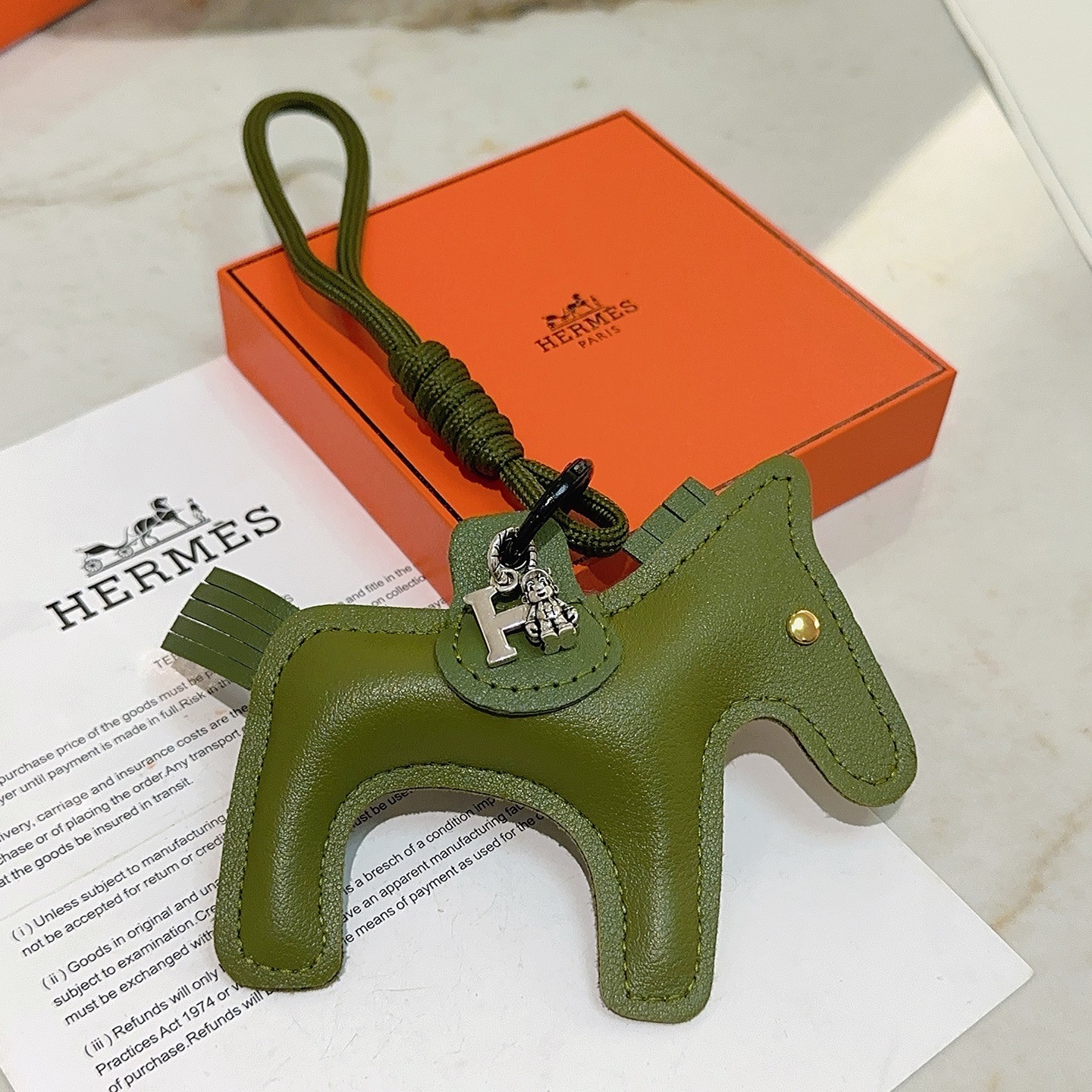 Ciondolo portachiavi Hermes Rodeo Horse Charm in pelle verde oliva con hardware in metallo argentato antico e rivetto dorato, lunghezza cordino 12 cm