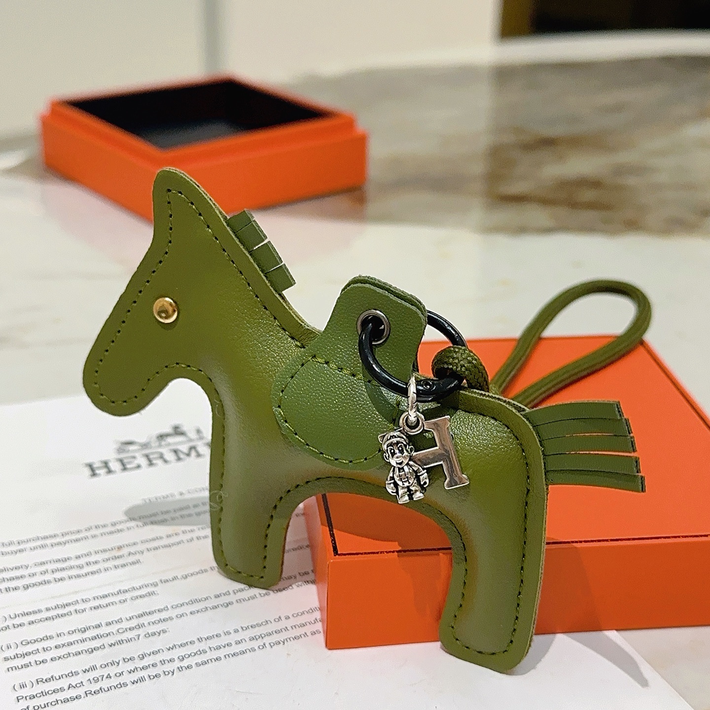 Ciondolo portachiavi Hermes Rodeo Horse Charm in pelle verde oliva con hardware in metallo argentato antico e rivetto dorato, lunghezza cordino 12 cm