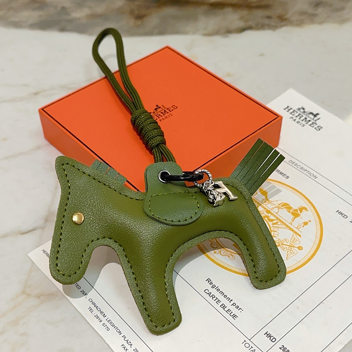 Ciondolo portachiavi Hermes Rodeo Horse Charm in pelle verde oliva con hardware in metallo argentato antico e rivetto dorato, lunghezza cordino 12 cm