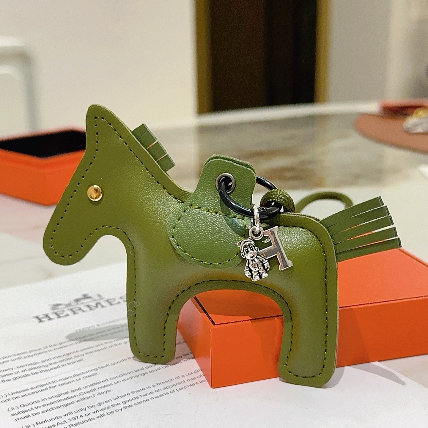 Ciondolo portachiavi Hermes Rodeo Horse Charm in pelle verde oliva con hardware in metallo argentato antico e rivetto dorato, lunghezza cordino 12 cm